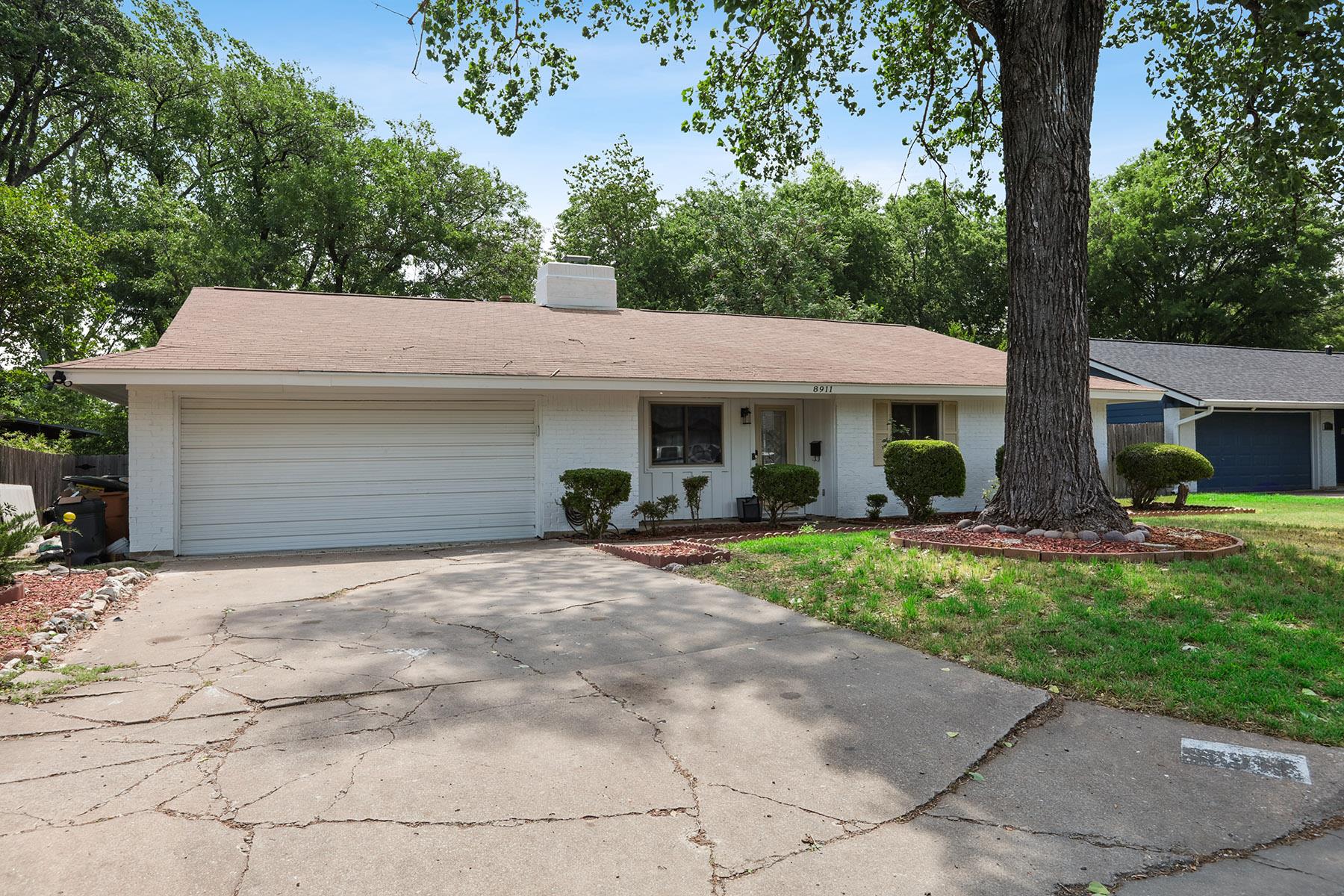 Mature trees shade a welcoming ranch-style facade