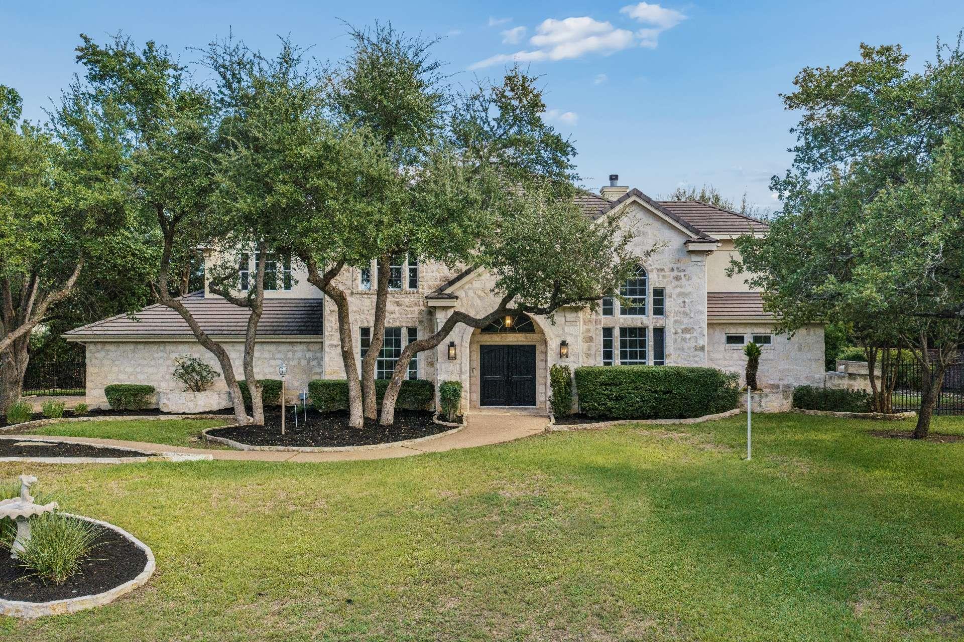 Mature trees shade a classic stone exterior with 
