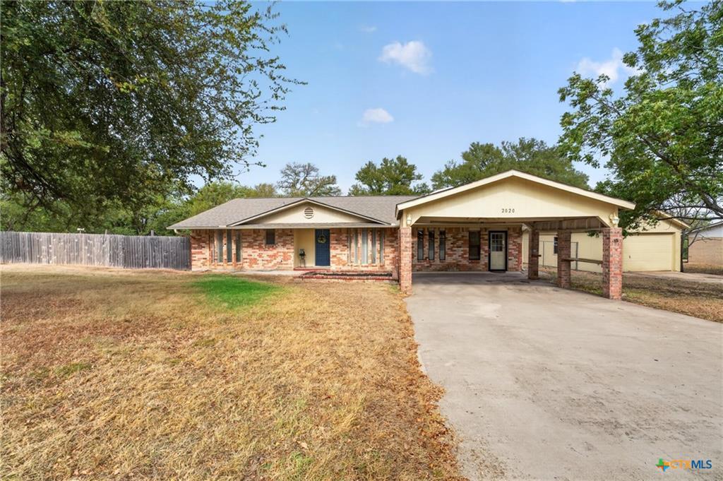 A classic brick exterior and attached carport fra