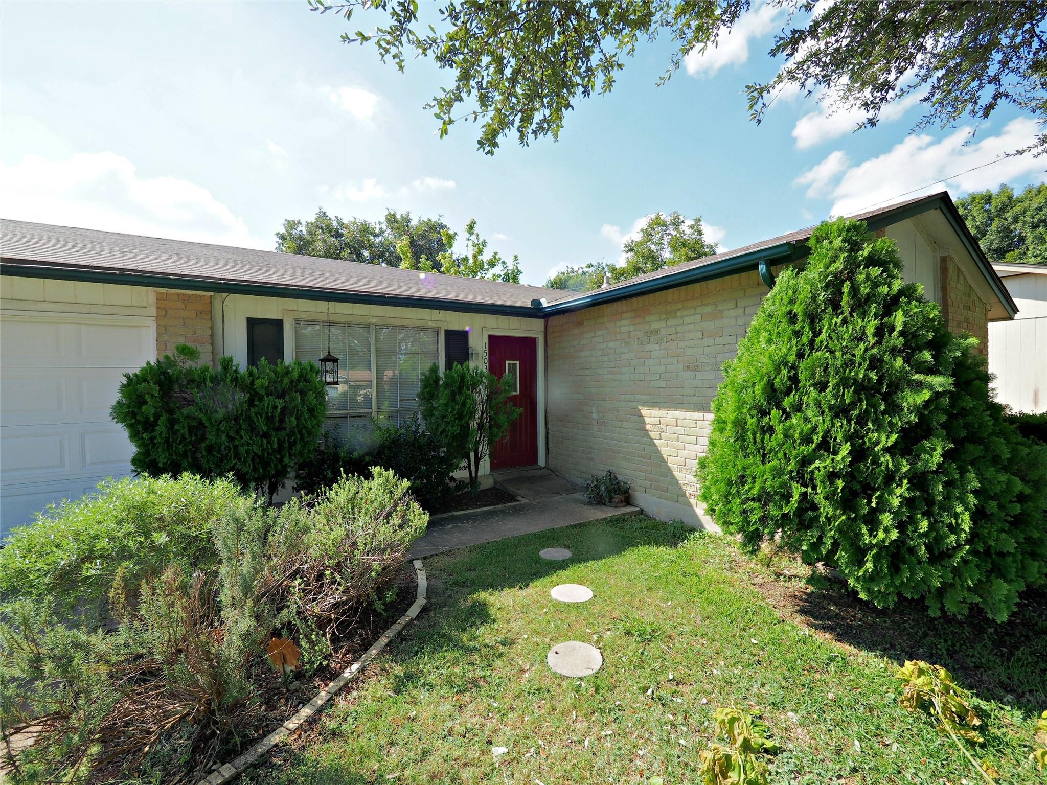 A welcoming red front door accents the classic br