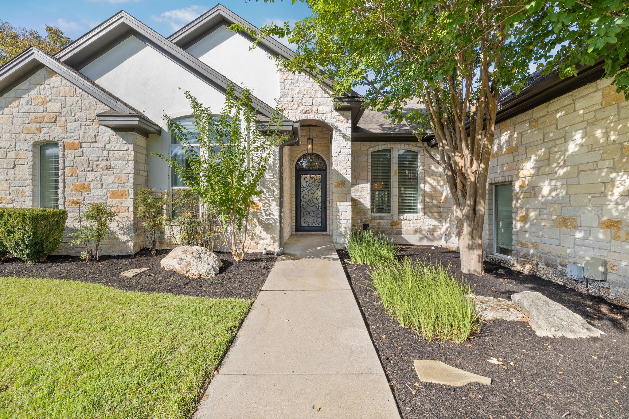 A concrete walkway leads to the welcoming arched 