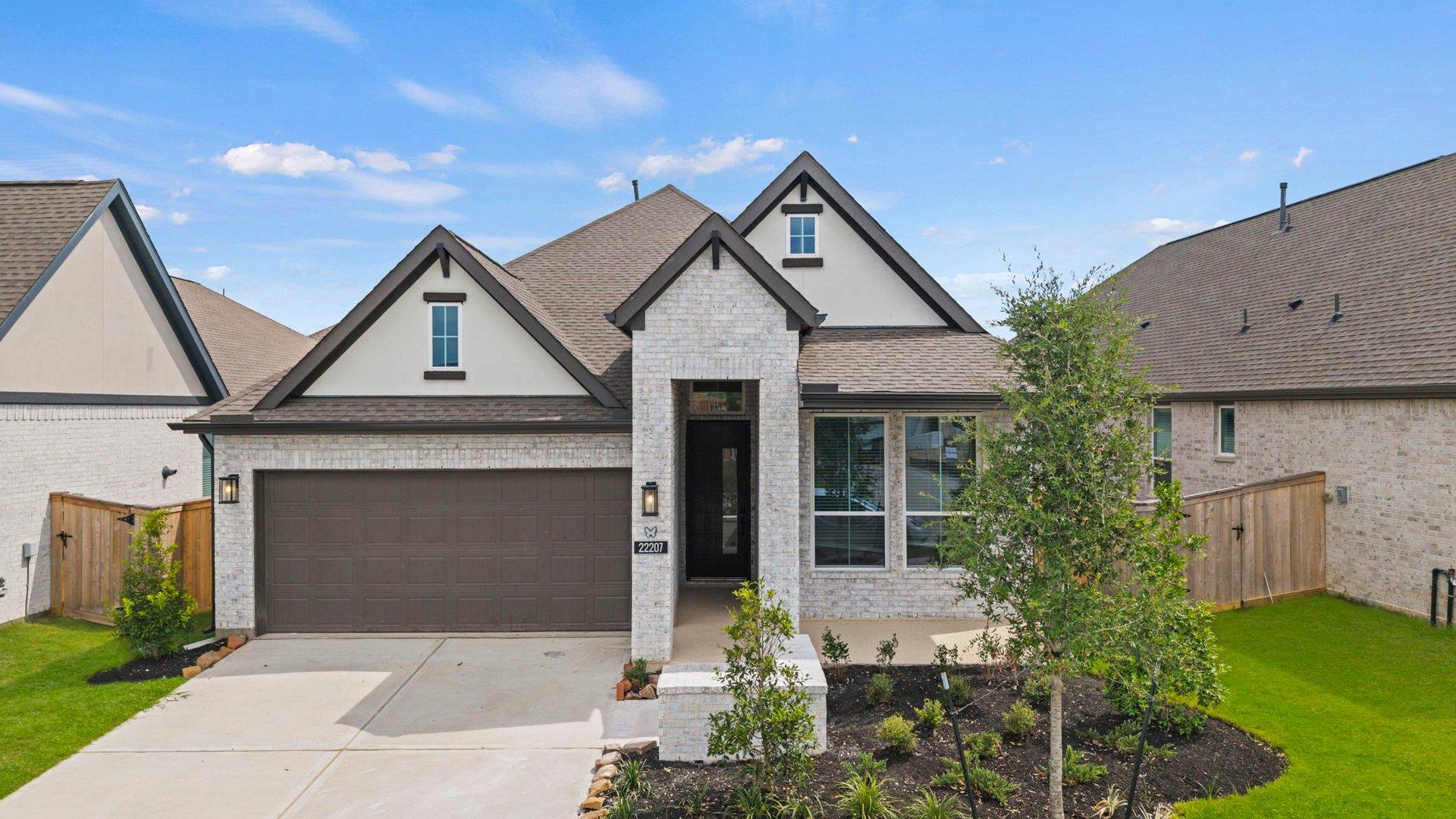 Multi-textured stone and siding accents define th