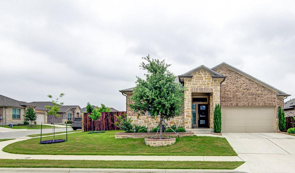 View of front of house with stone siding, drivewa