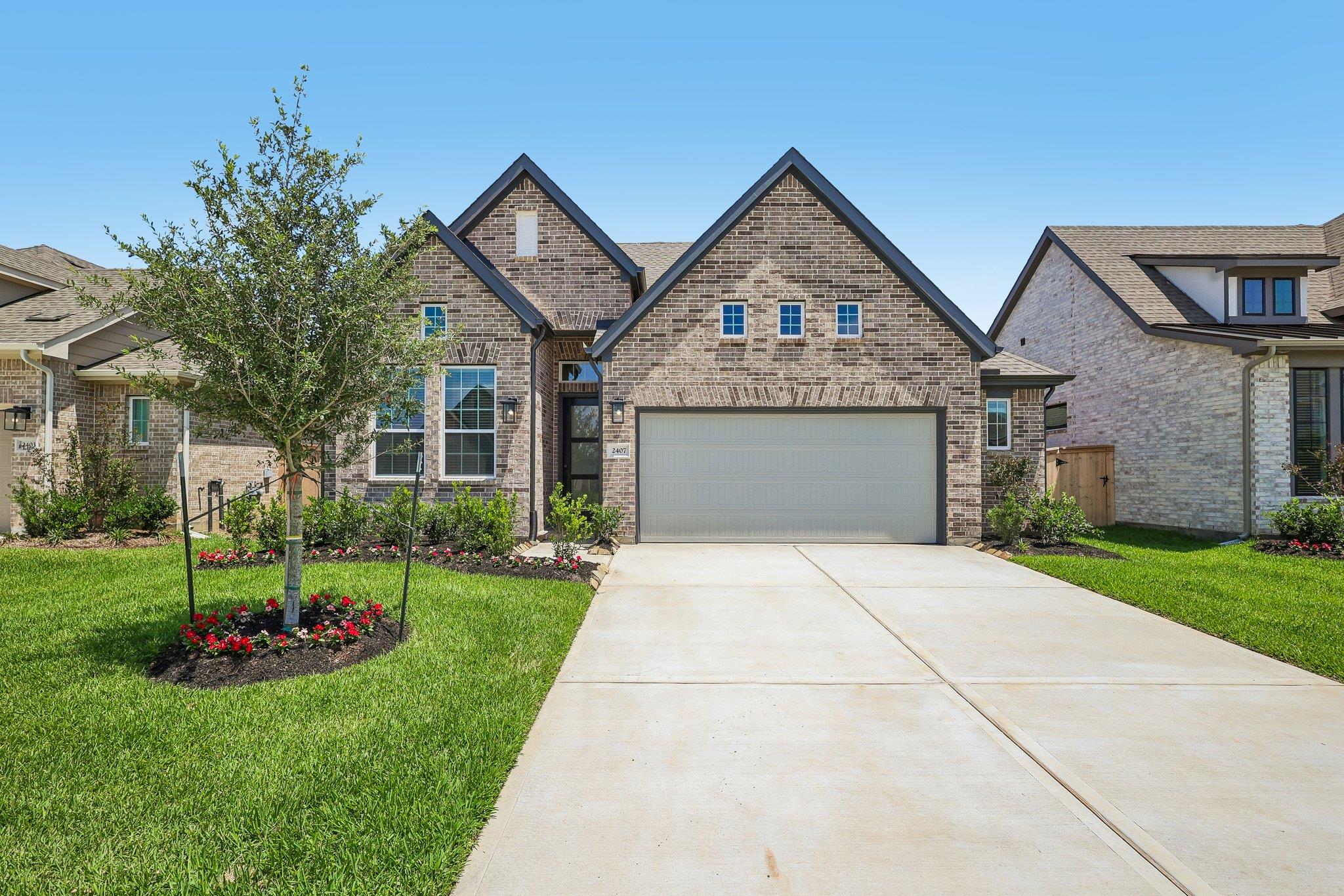 A classic brick exterior and concrete driveway le