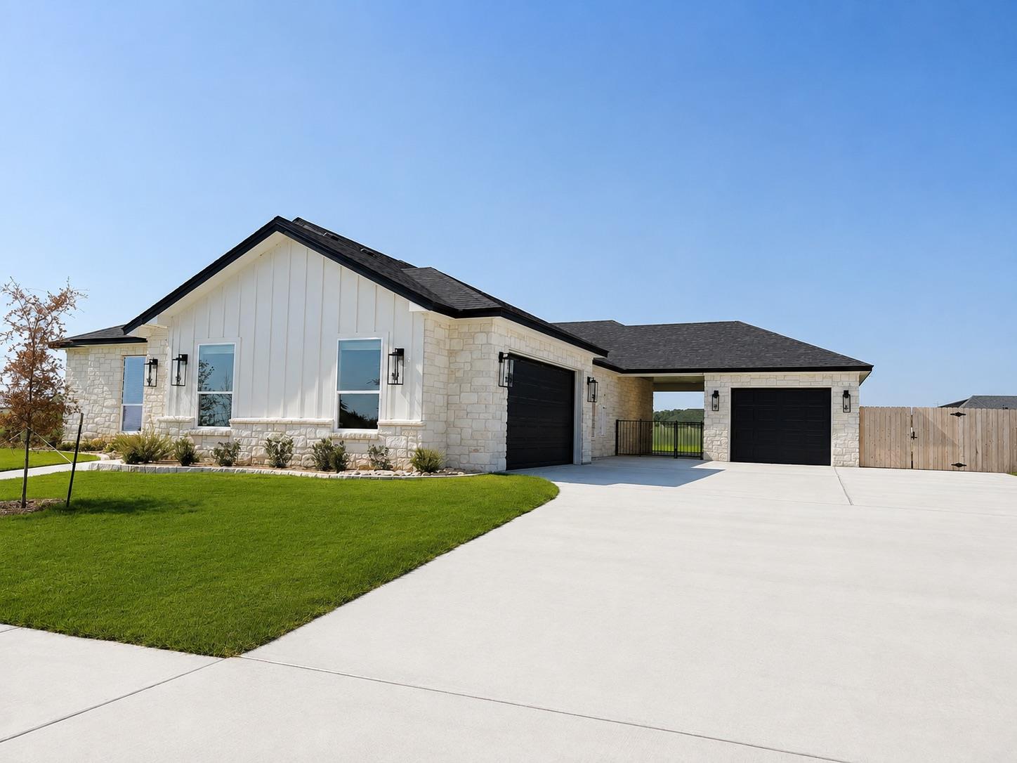 An expansive concrete driveway leads to a modern 