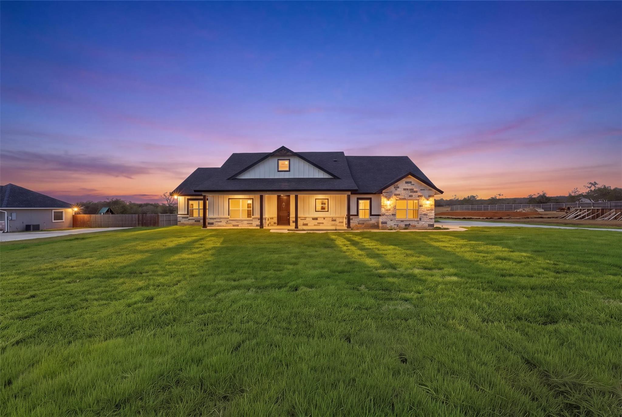 An expansive green lawn leads to a contemporary s