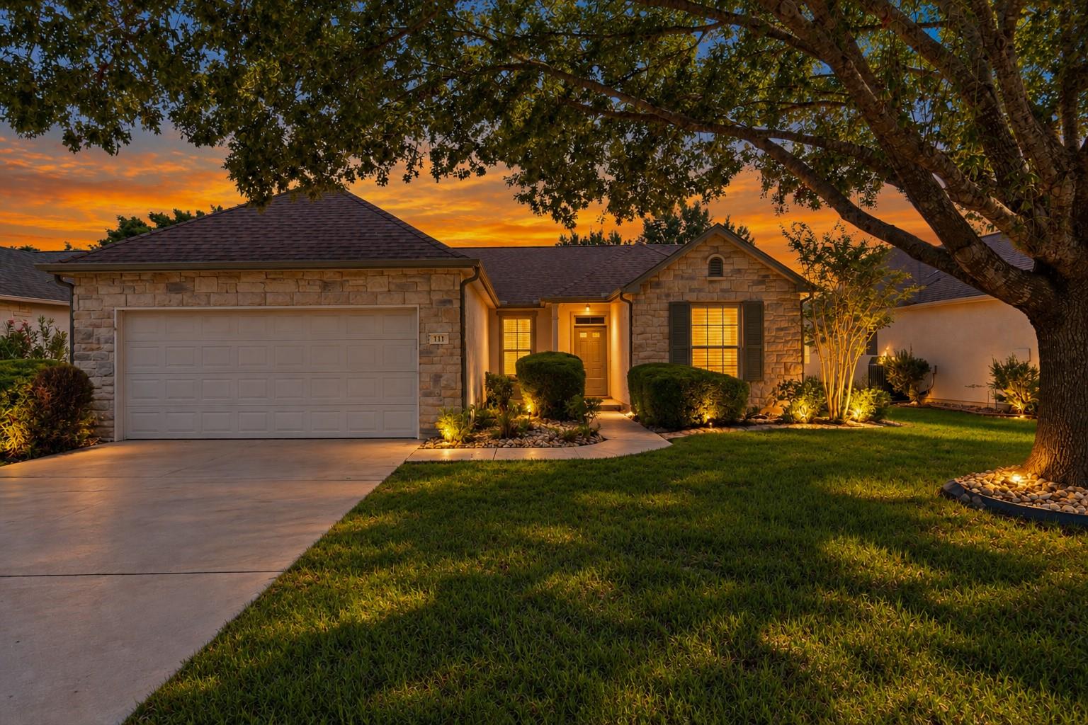 A stone facade and pristine landscaping welcome v