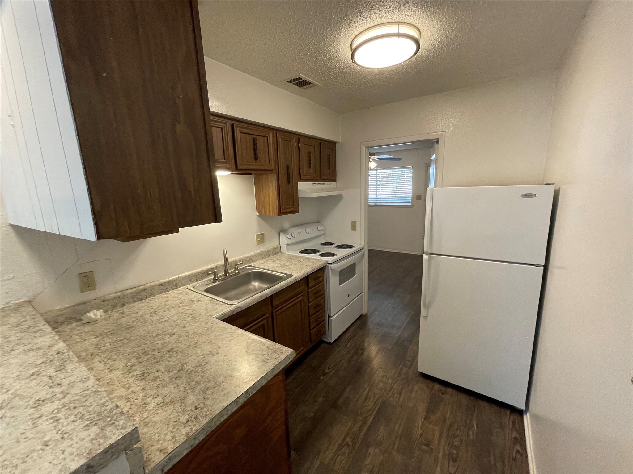 Laminate countertops and rich wood cabinetry defi