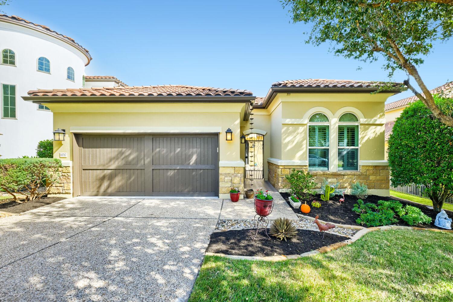 Clay tile roofing and stone accents lend Mediterr