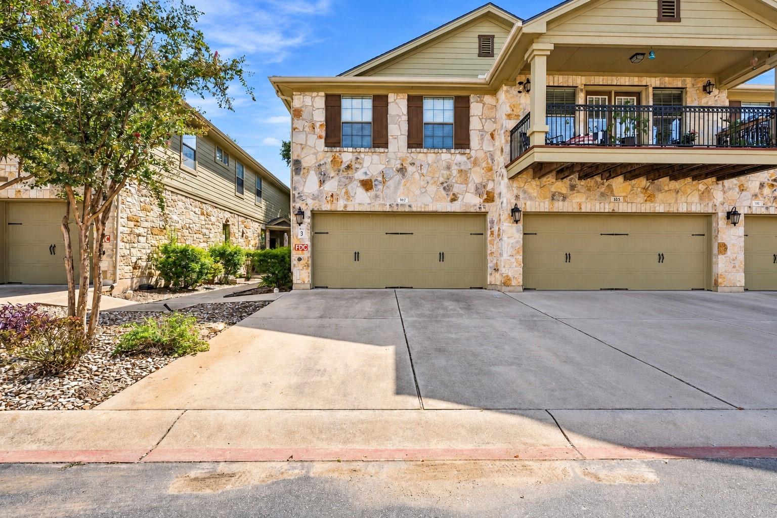 Natural stone masonry and multiple garage bays de