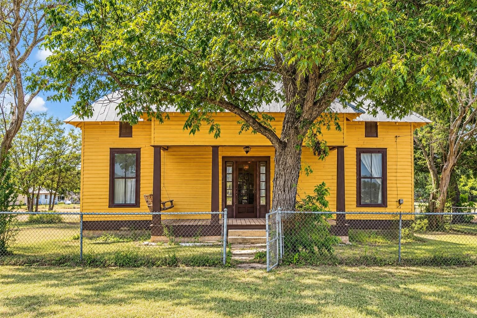 Mature shade trees frame a covered front porch we