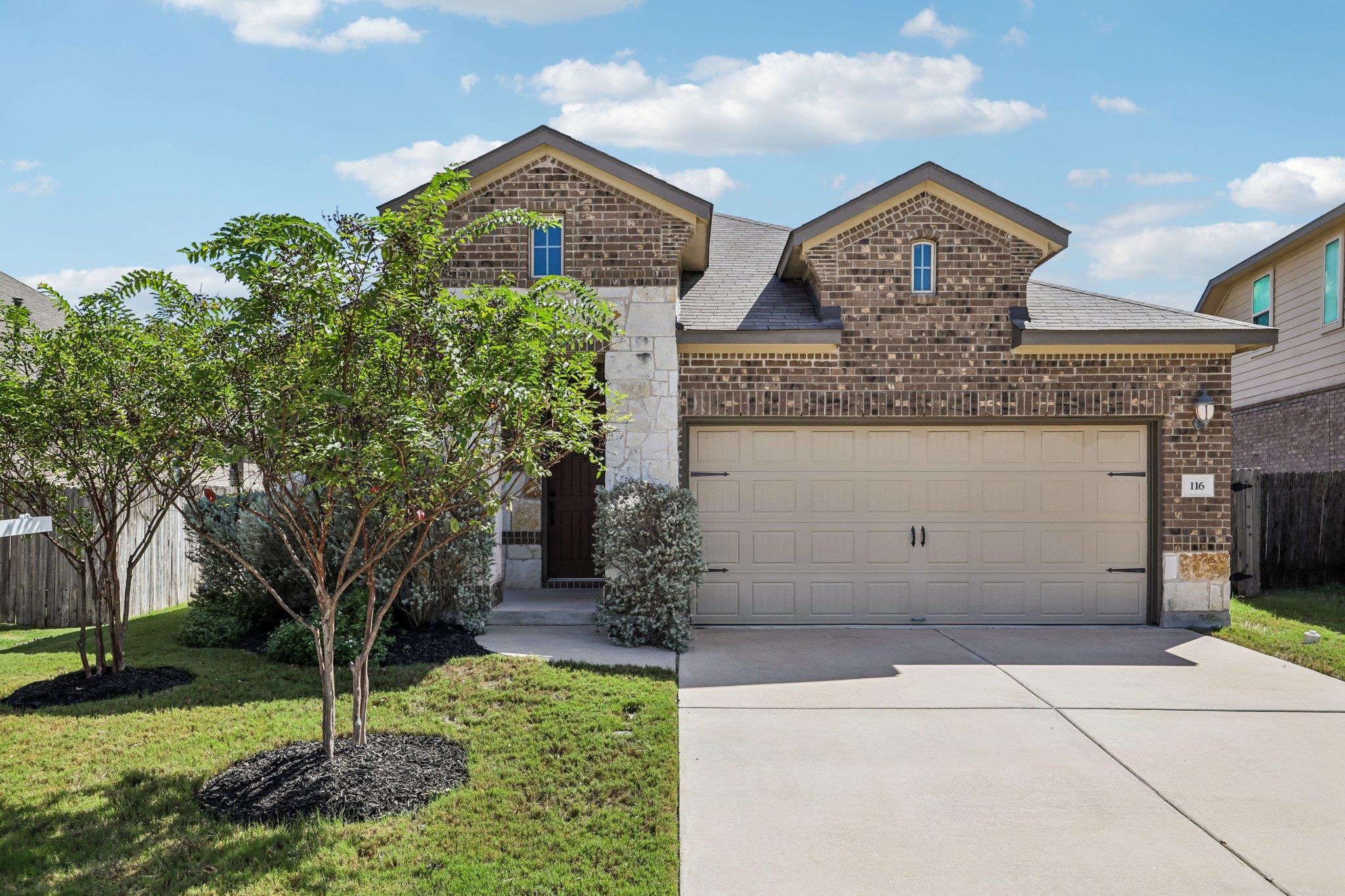 A classic brick exterior pairs with a concrete dr