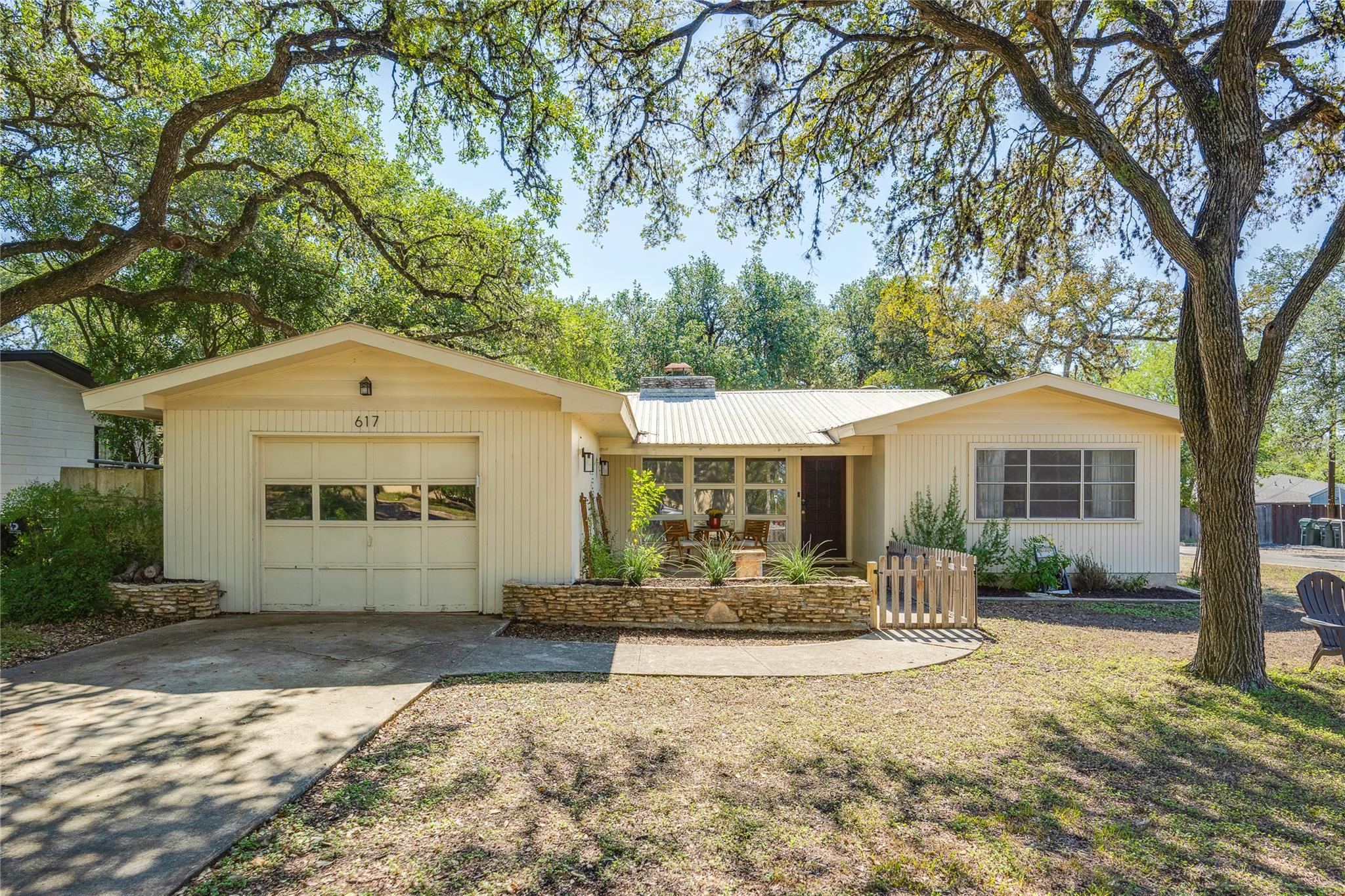 Mature oak trees shade the front yard of this cla