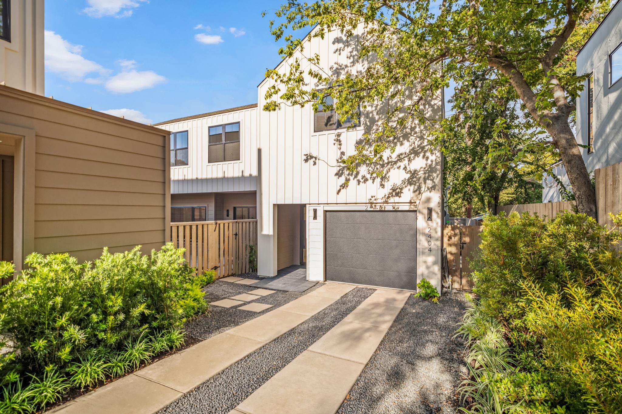 Modern vertical siding and a neat paved driveway 