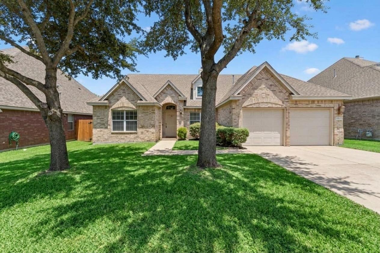 Mature shade trees frame a classic brick exterior