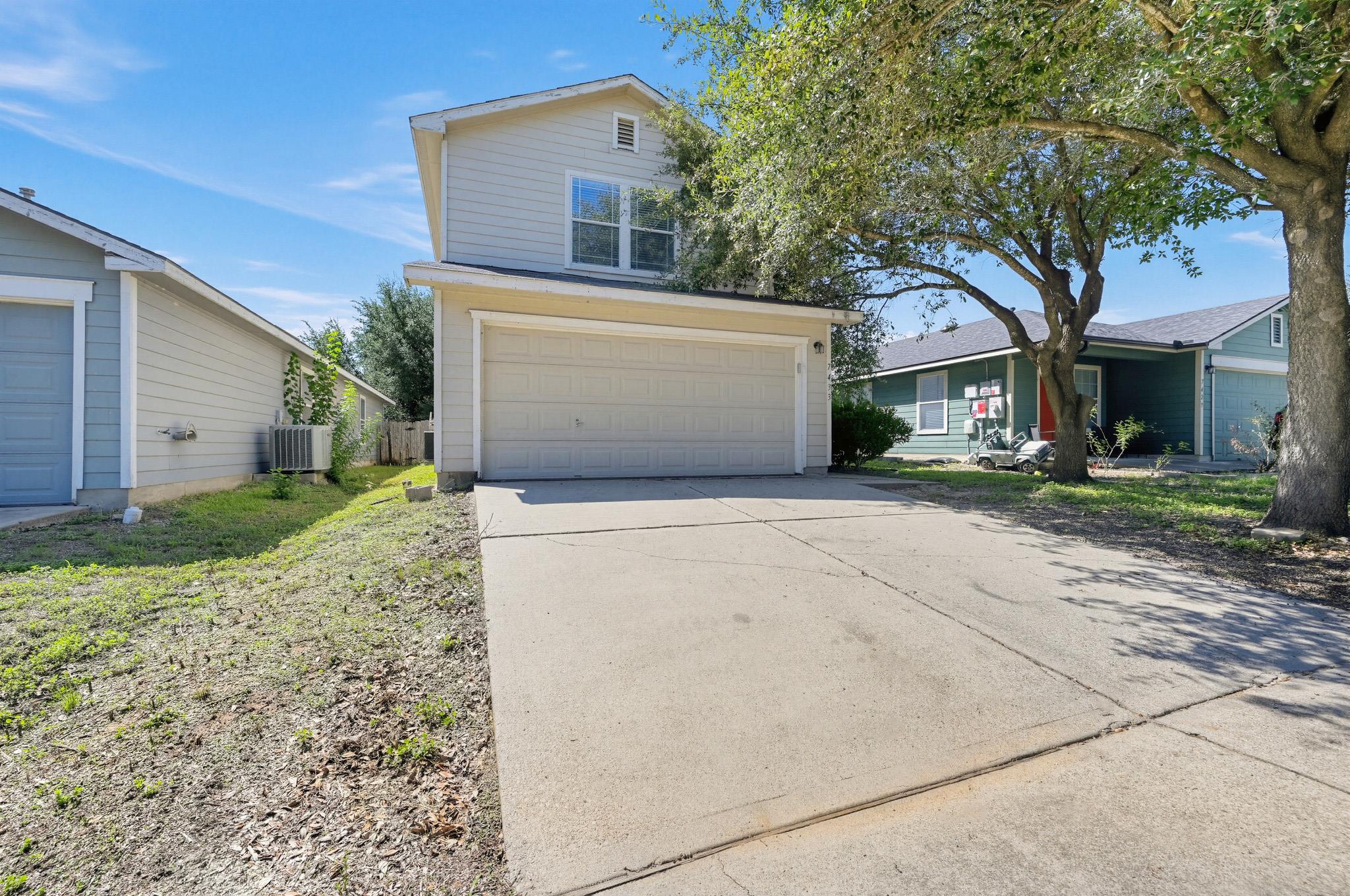 An attached two-car garage fronted by a wide conc