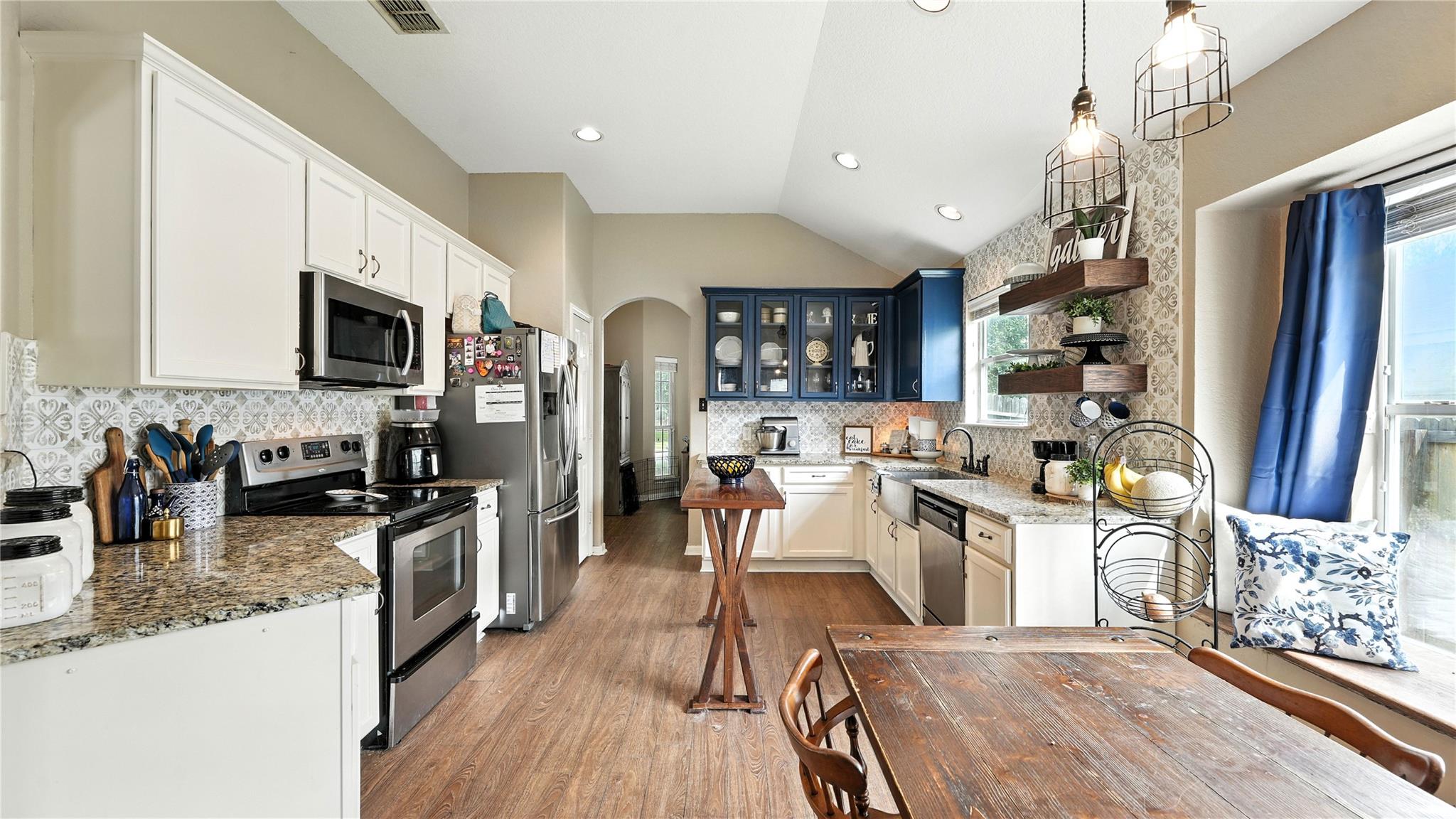 Gleaming stone countertops and warm wood floors d
