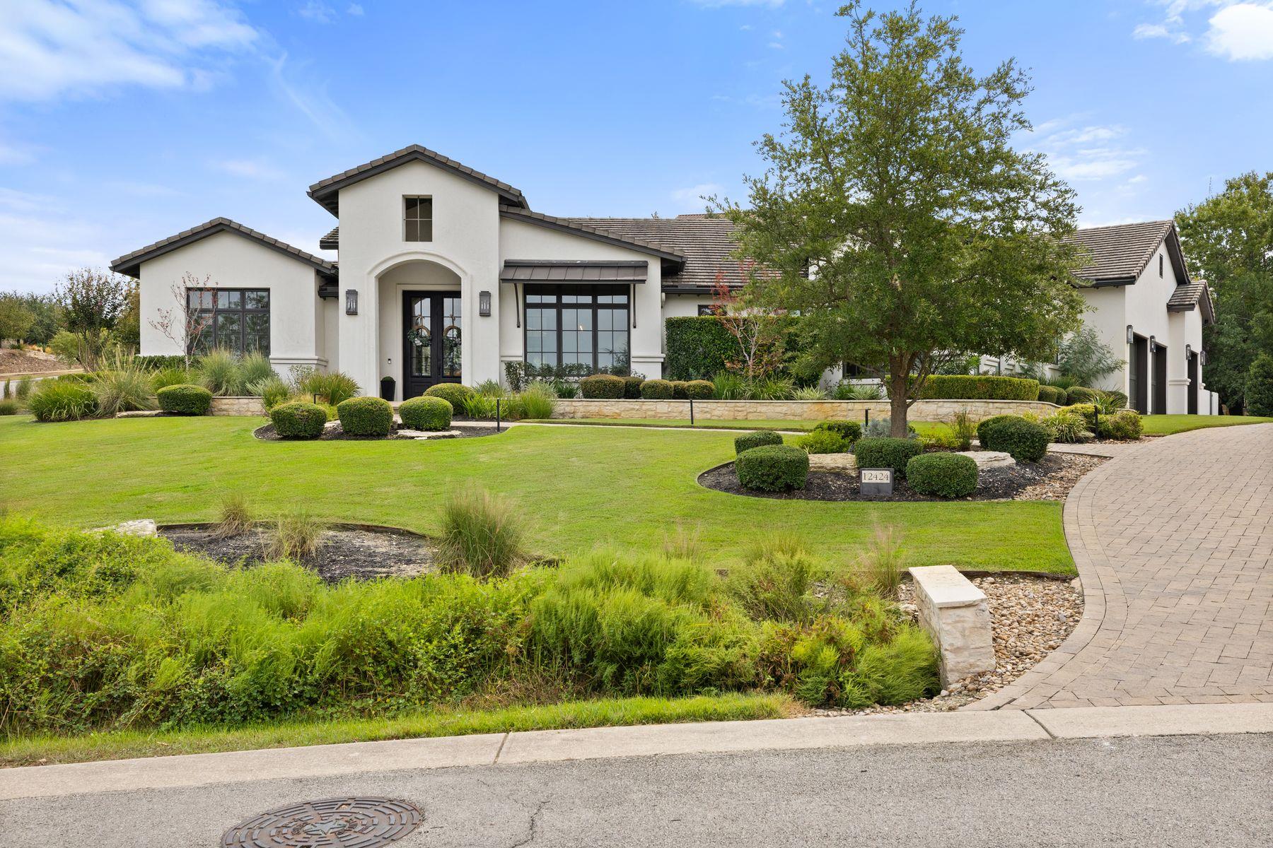 Manicured landscaping complements the clean stucc