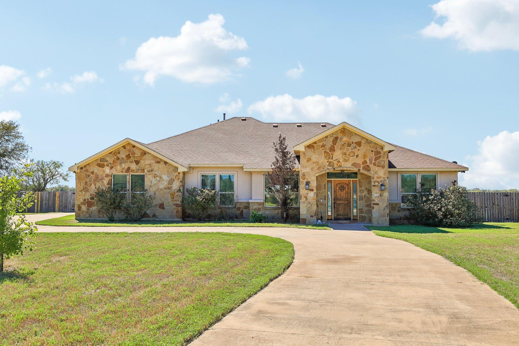 Natural stone accents and a sweeping driveway wel