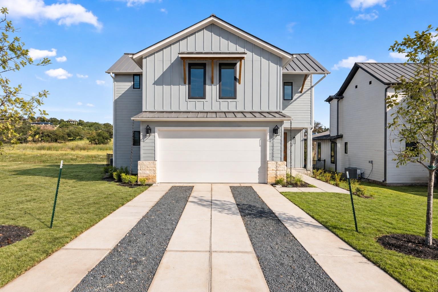 Modern vertical siding and a striking paved drive