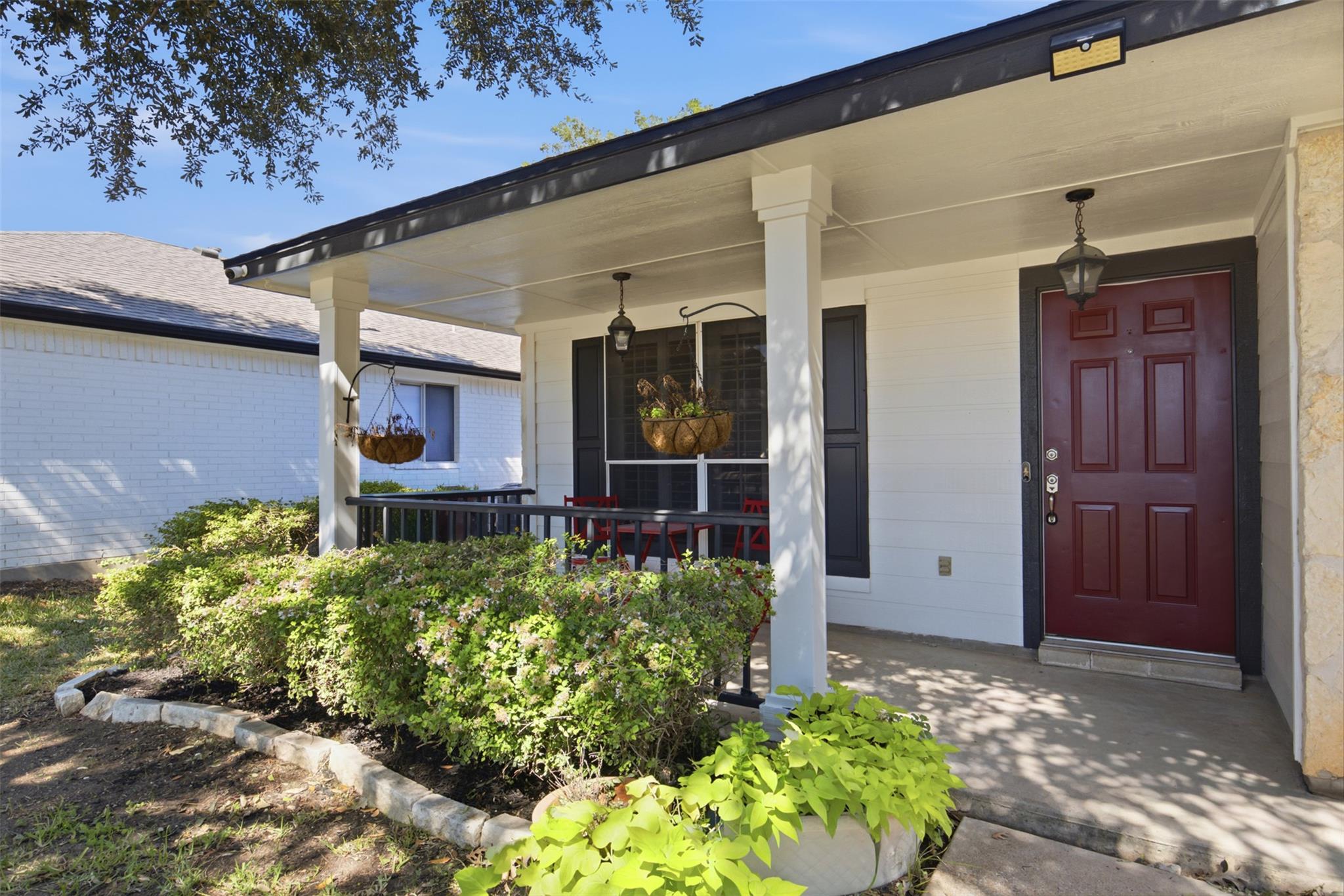 Welcoming front porch entry framed by stone-edged