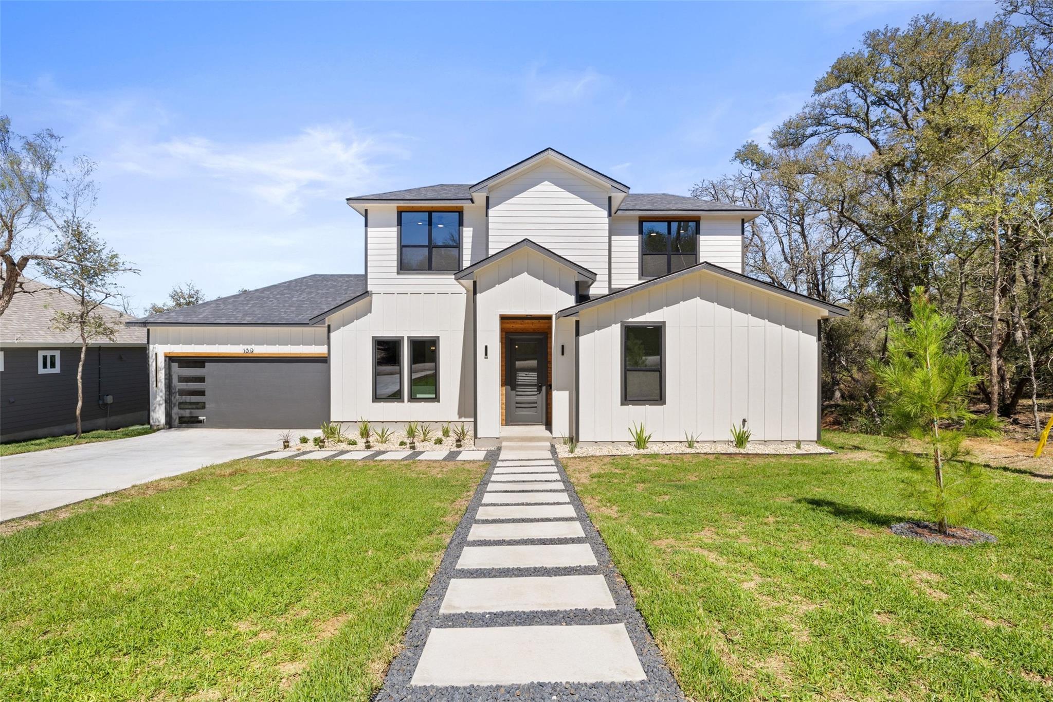 Modern vertical siding and a geometric paver walk
