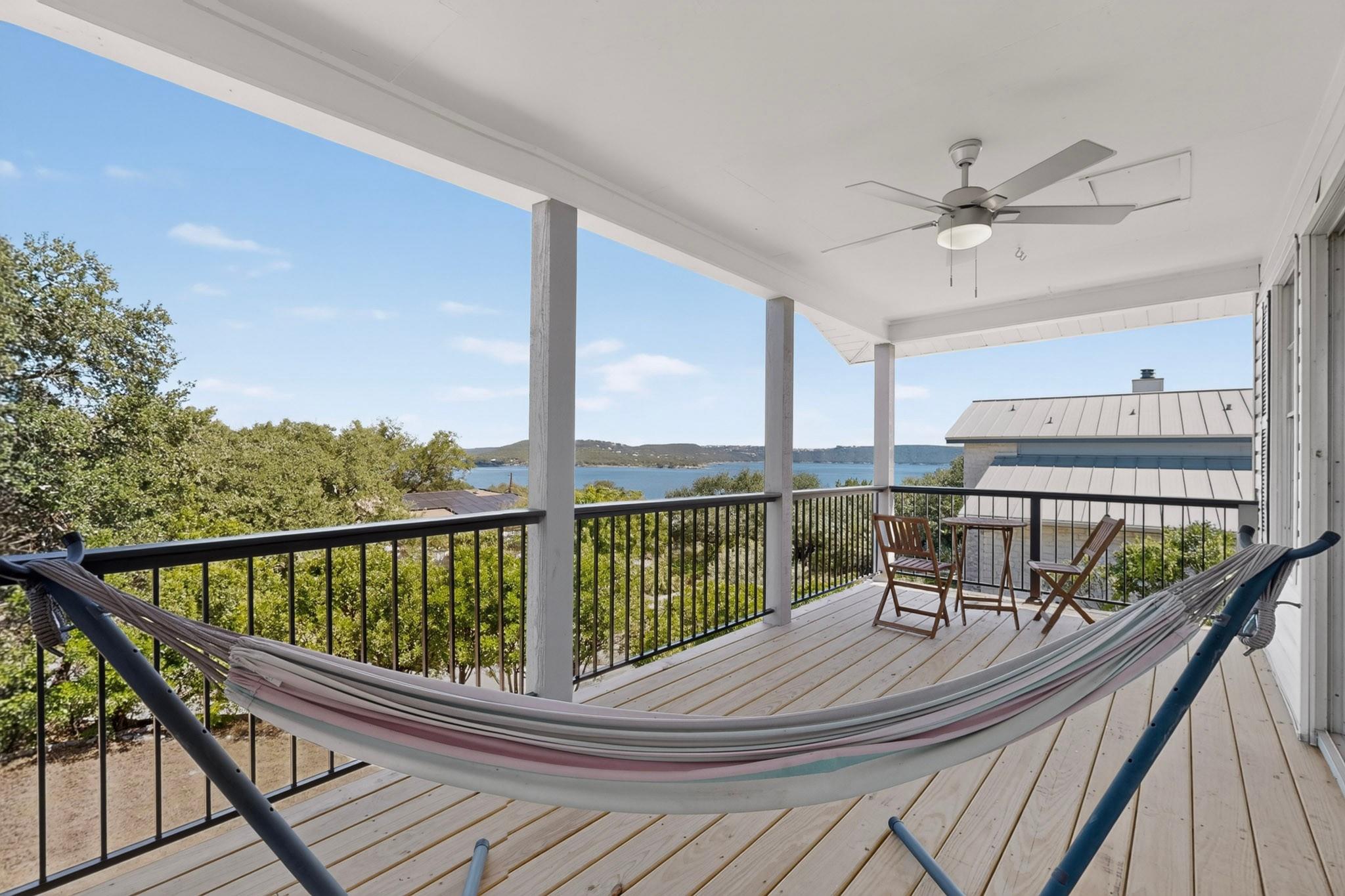 A spacious covered deck overlooks distant water v