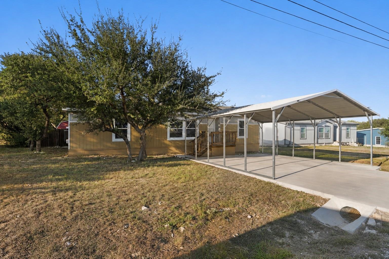 A spacious concrete driveway leads to a covered m
