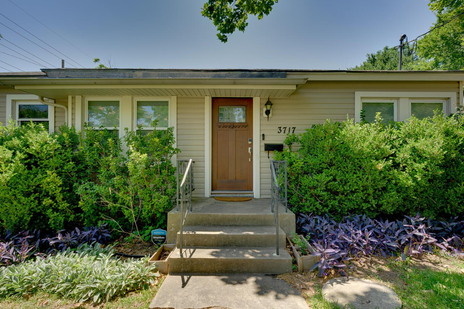 Concrete steps lead to a classic wood entry door 