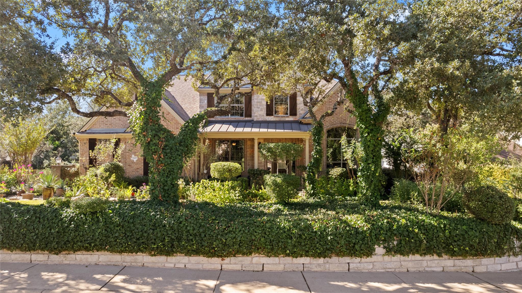 Mature oak trees and lush ivy framing a classic b