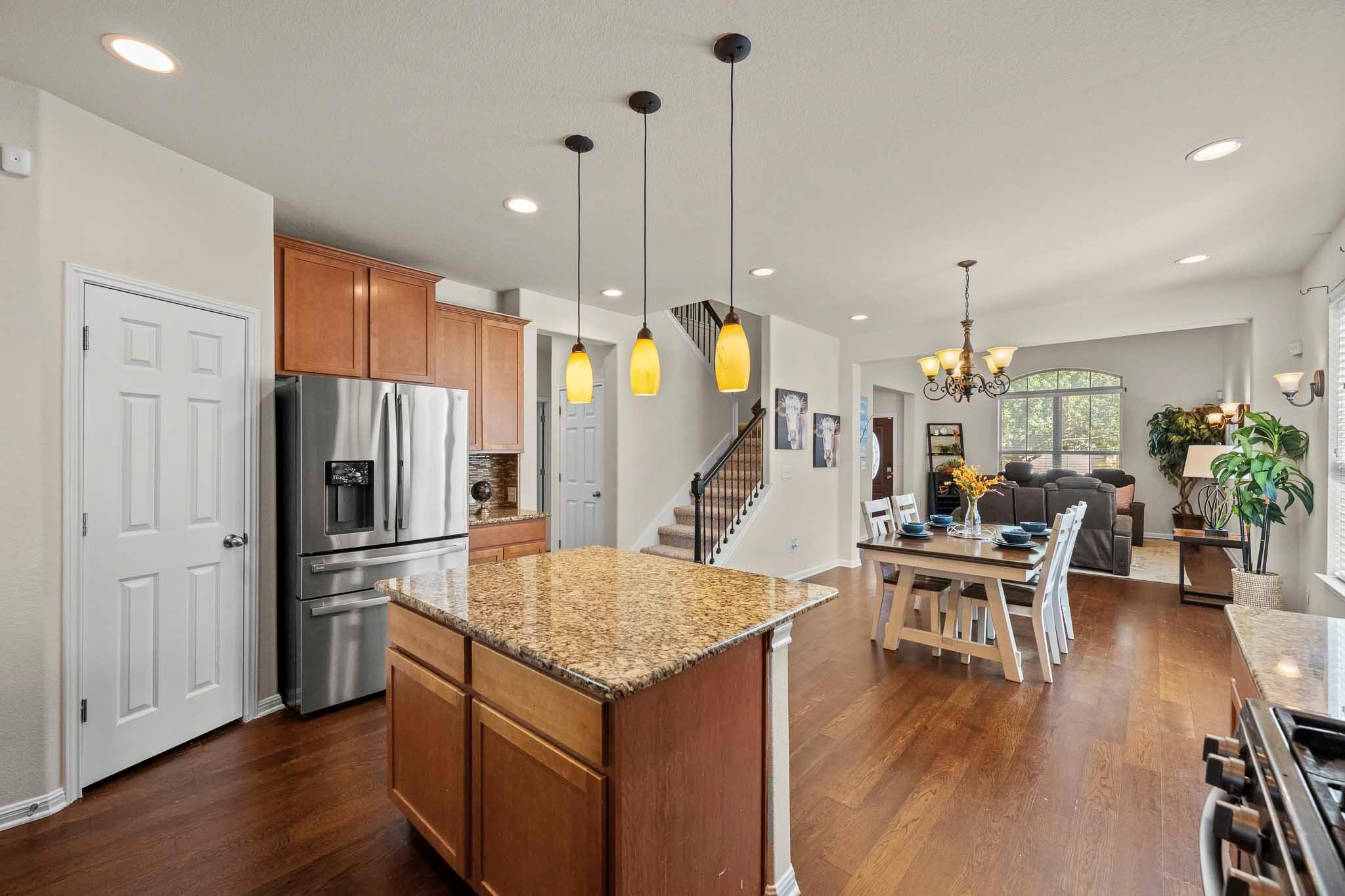 Warm hardwood floors connect a central kitchen is