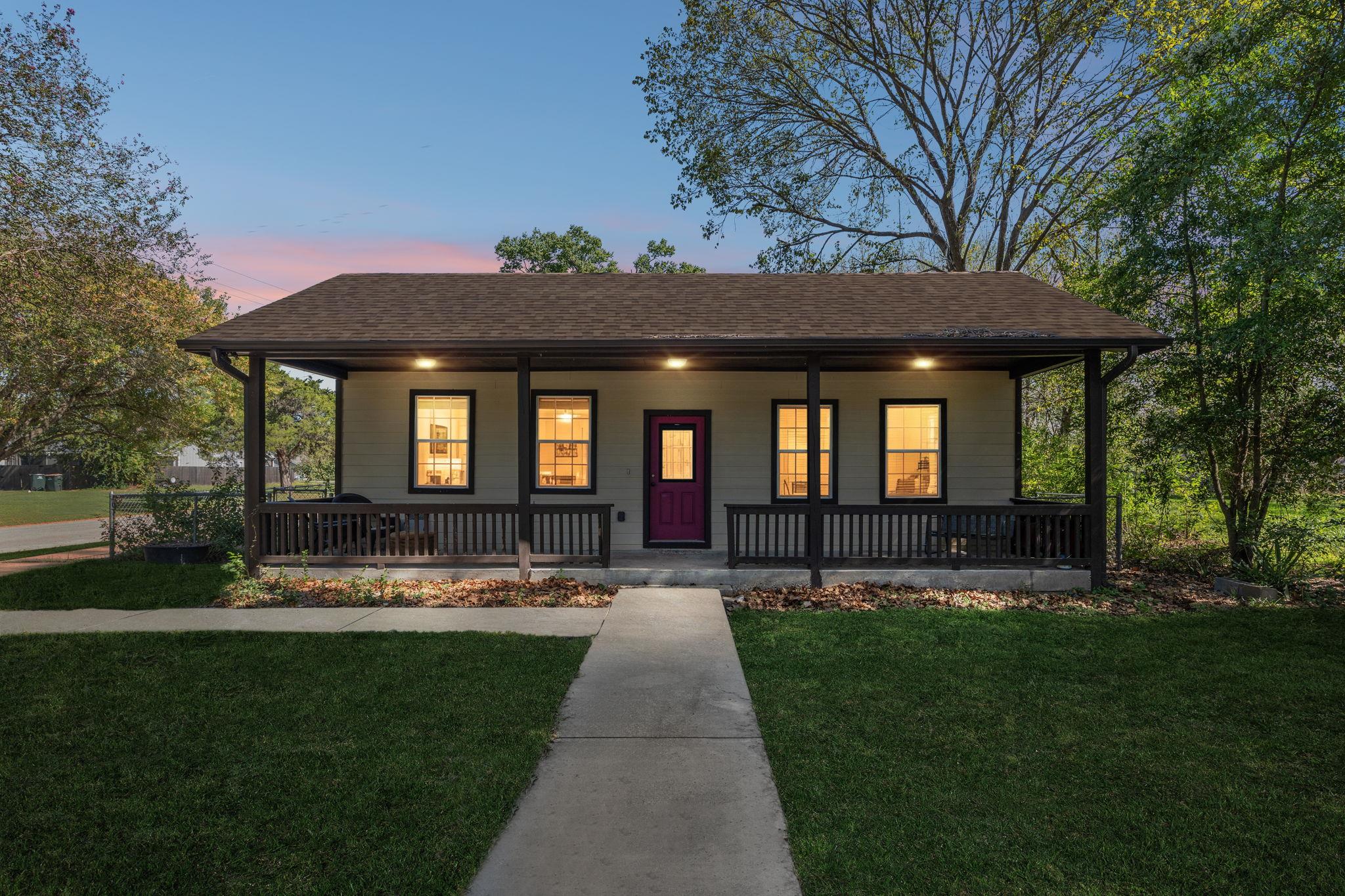 A concrete walkway leads to the welcoming covered