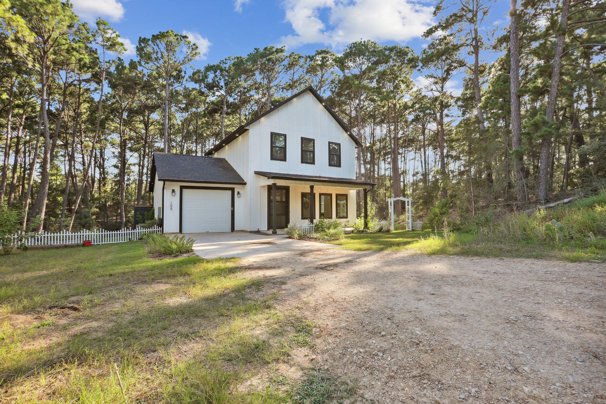 Tall pines frame a modern two-story farmhouse com
