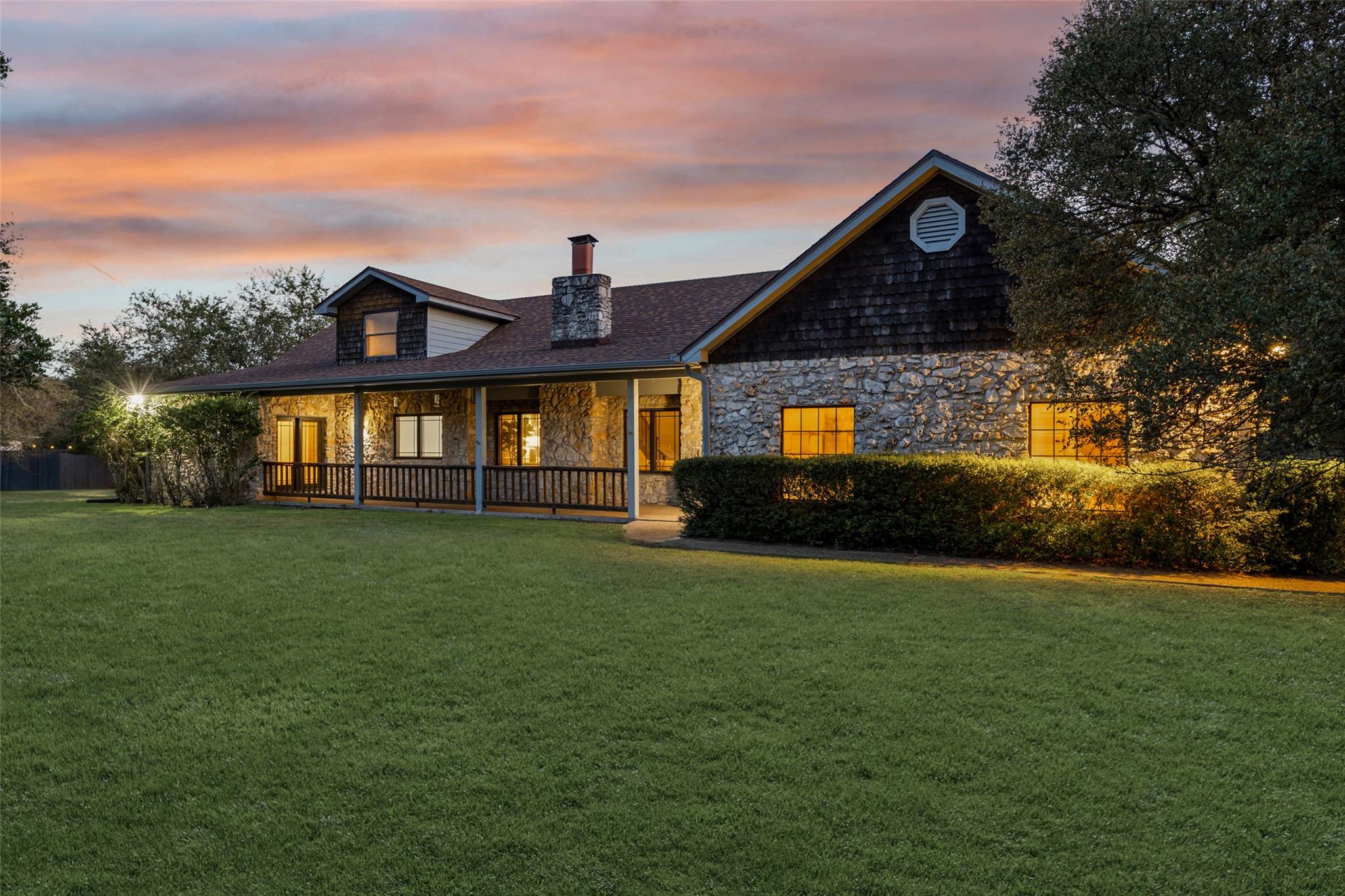 Stone masonry and a deep covered porch define thi