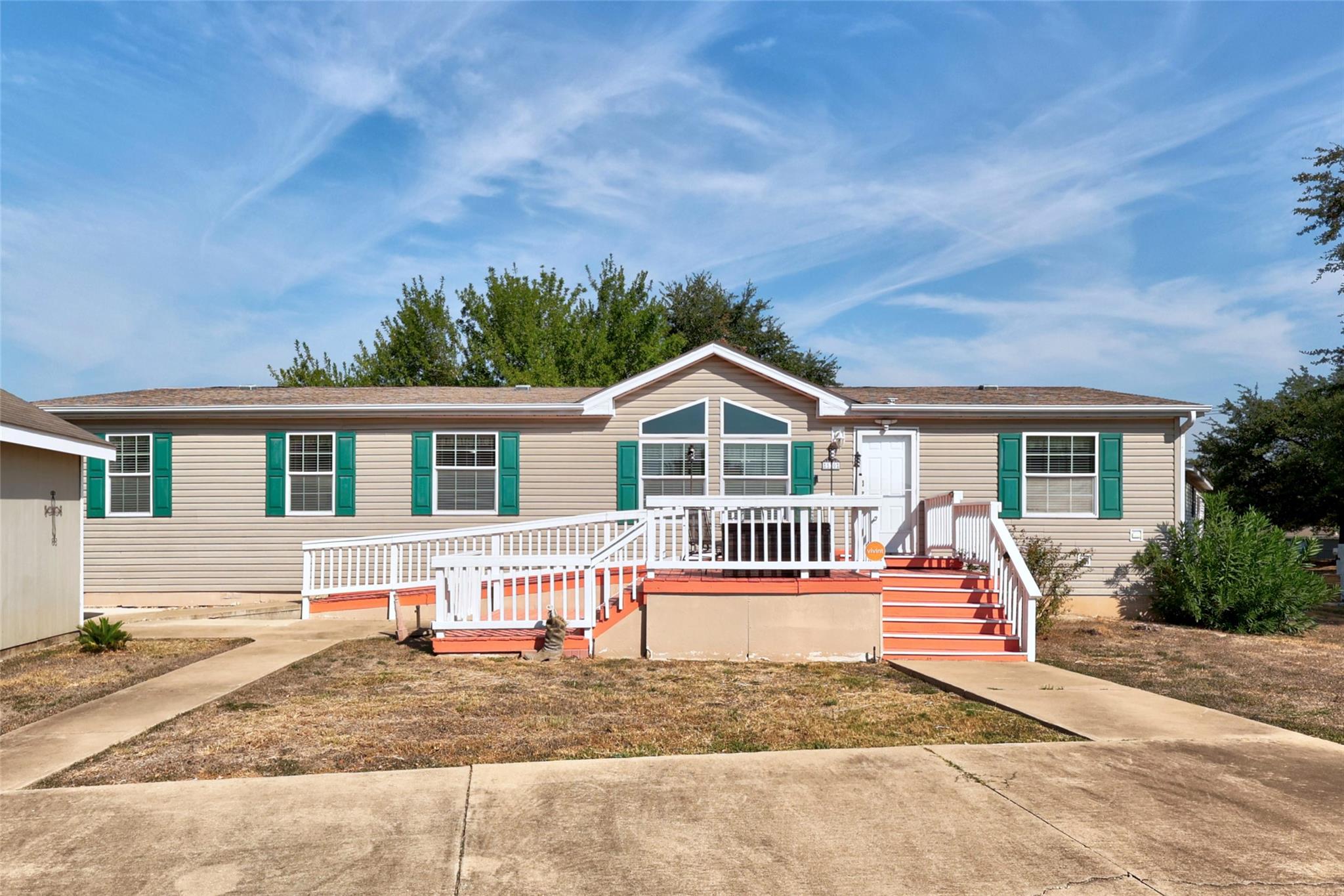 Concrete walkways lead to a covered front porch f