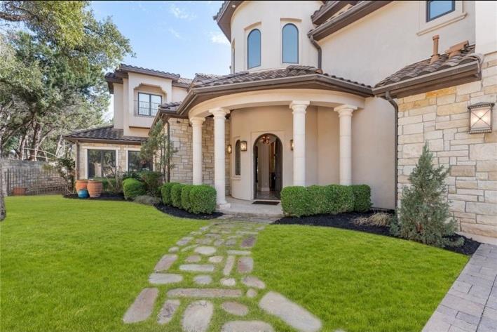 Elegant columns and a stone pathway lead to the g