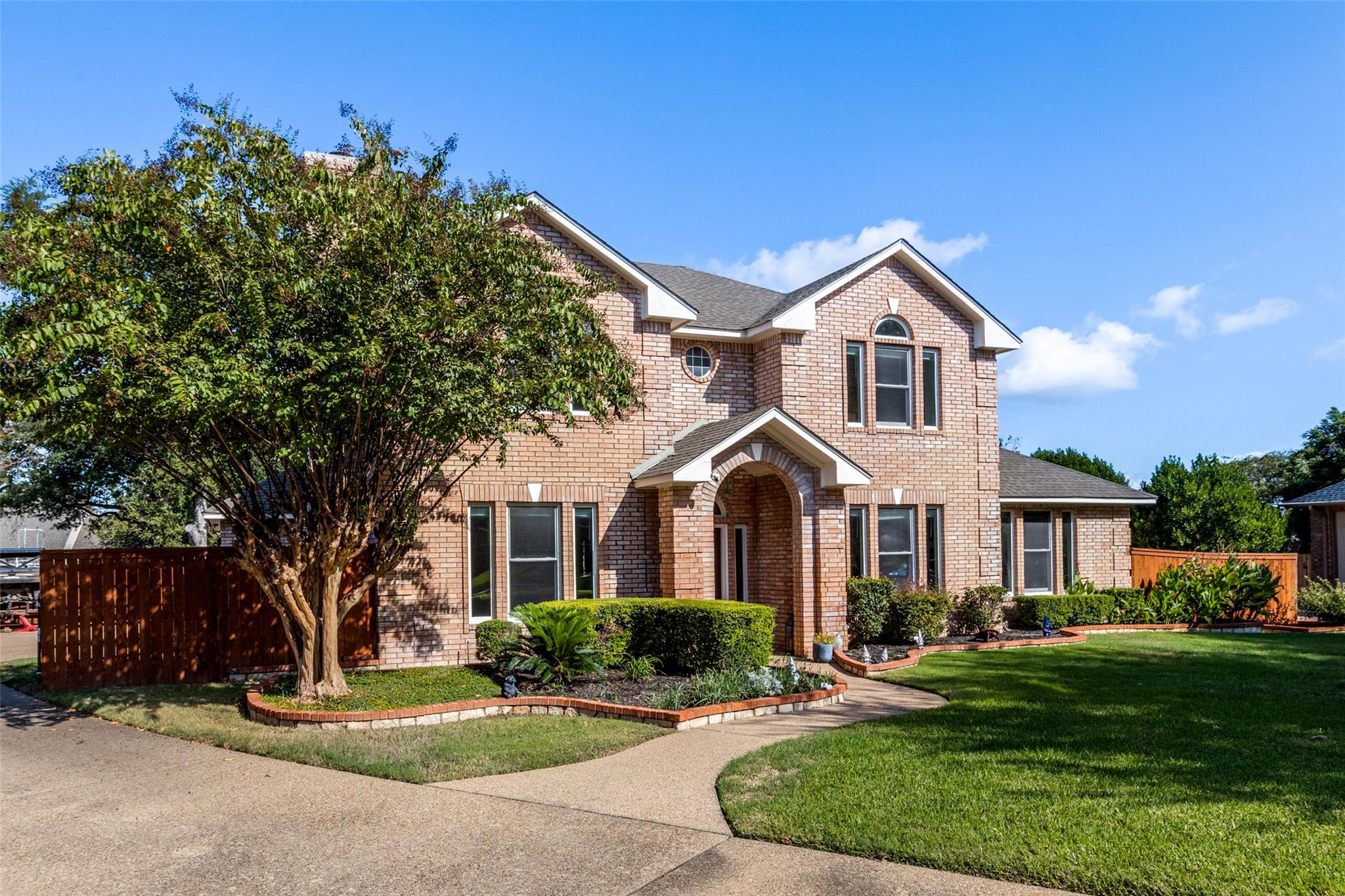 An arched entry and classic brick facade create t