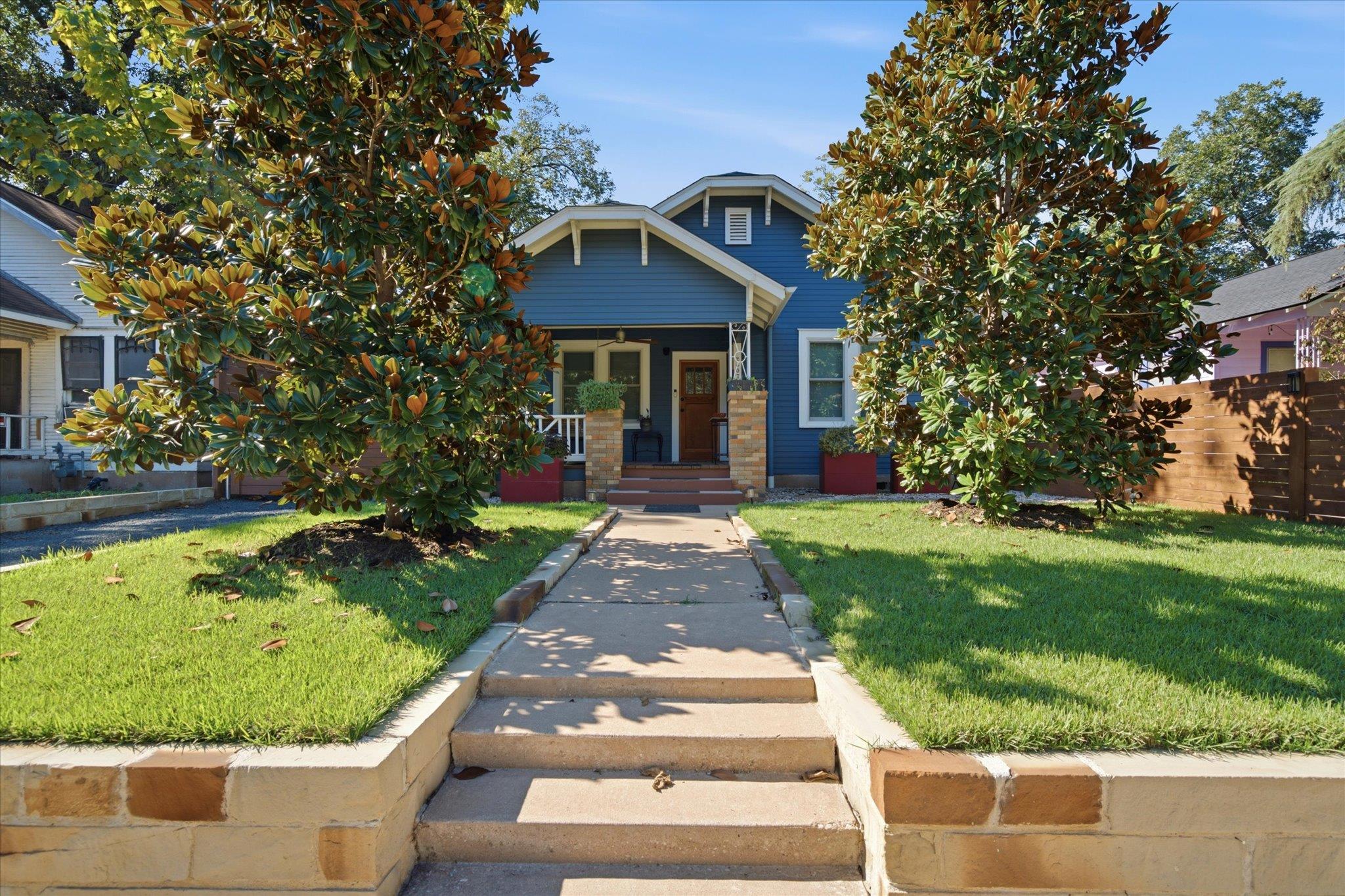 A concrete walkway rises through a terraced lawn 