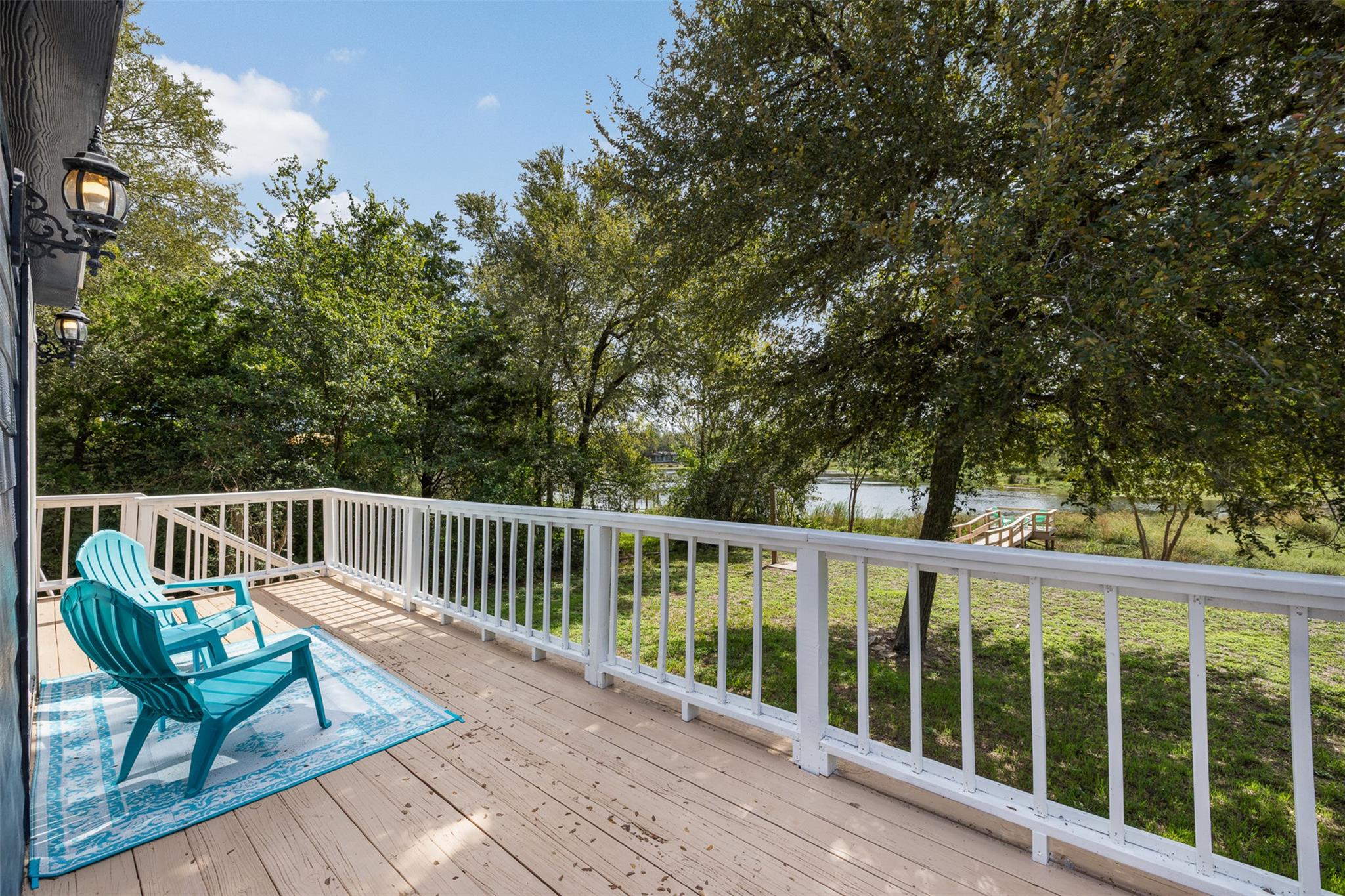 An elevated wooden deck overlooks a tranquil yard