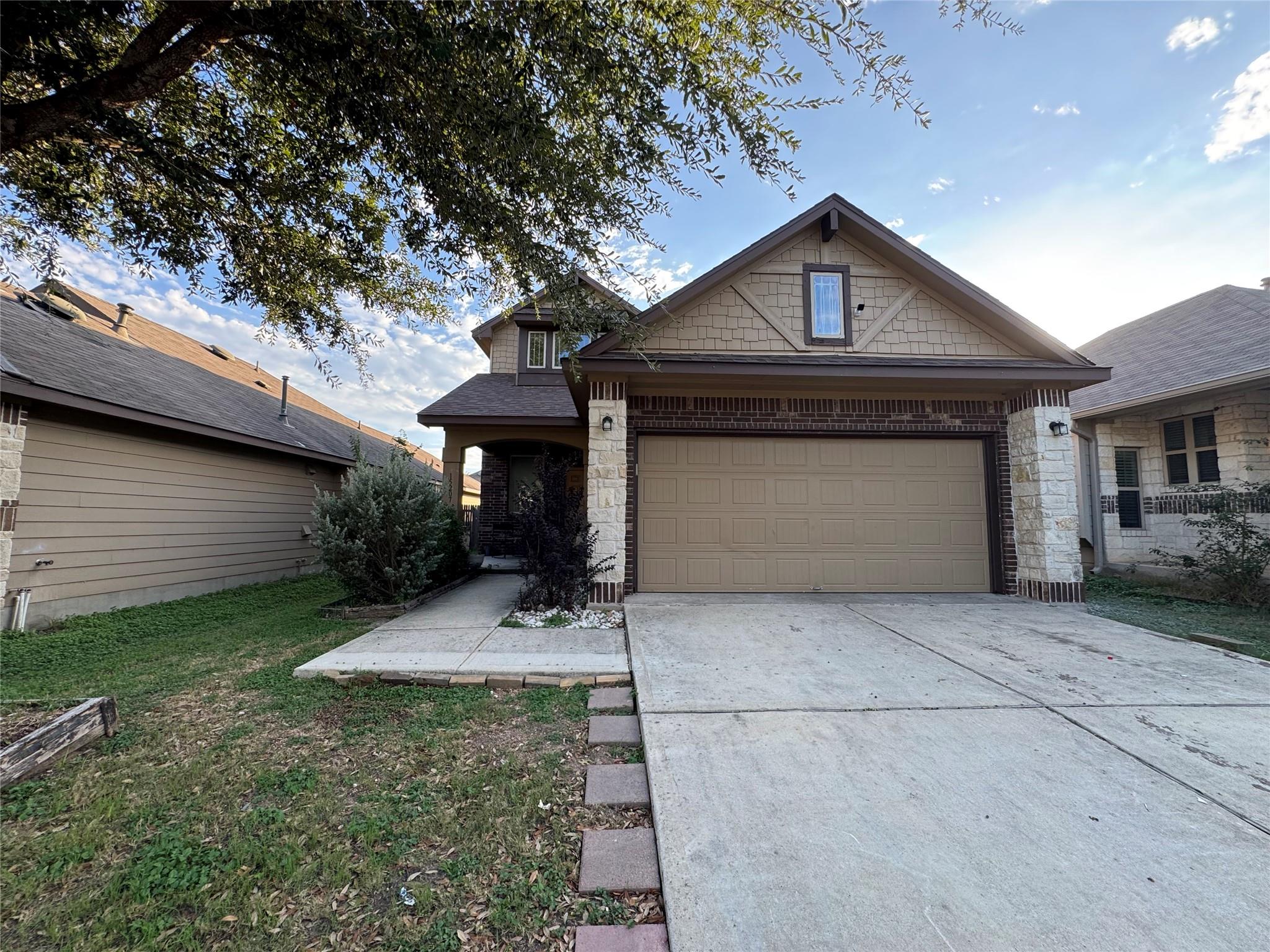A concrete driveway leads to the two-car garage o