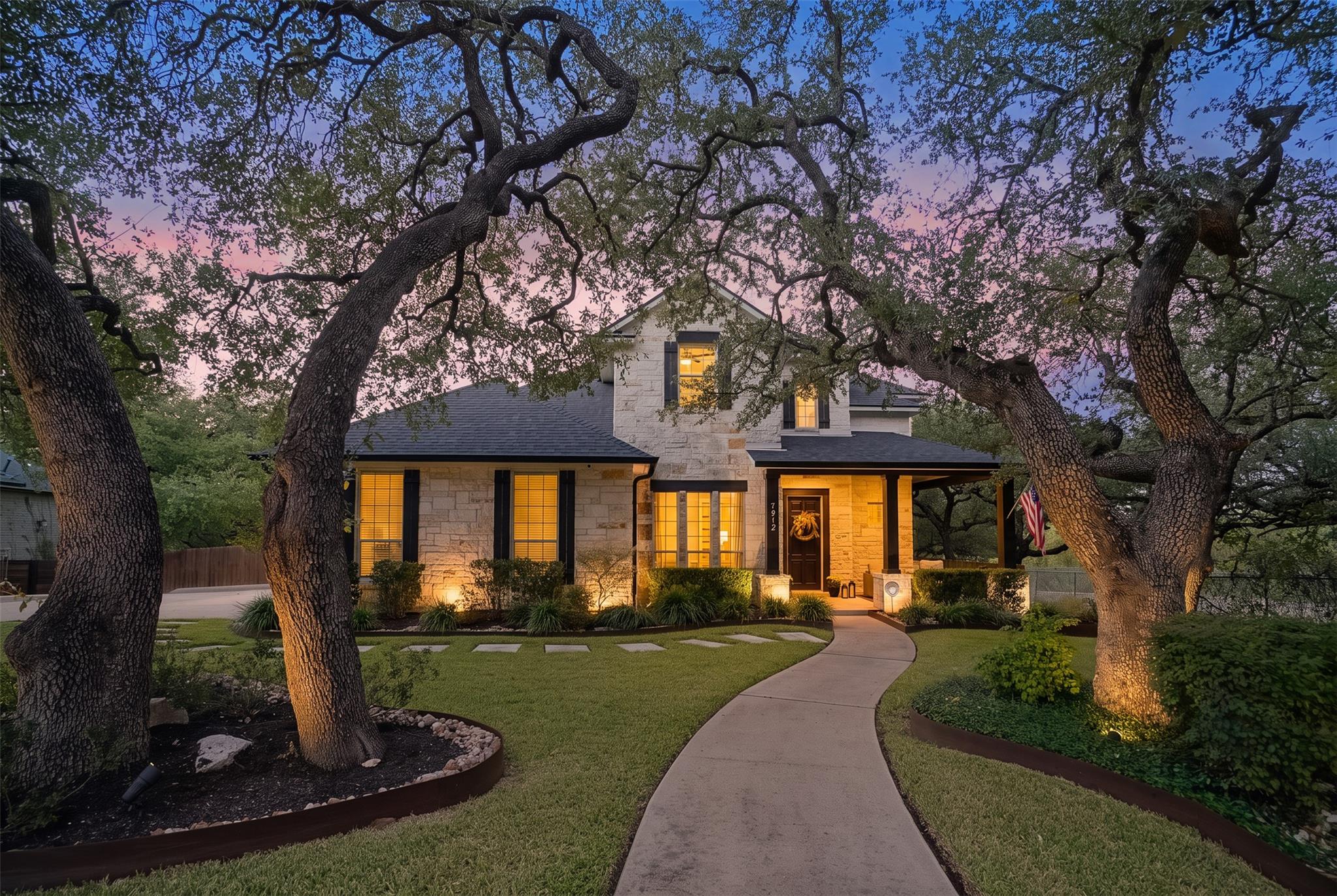 Mature oak trees frame a curved pathway leading t