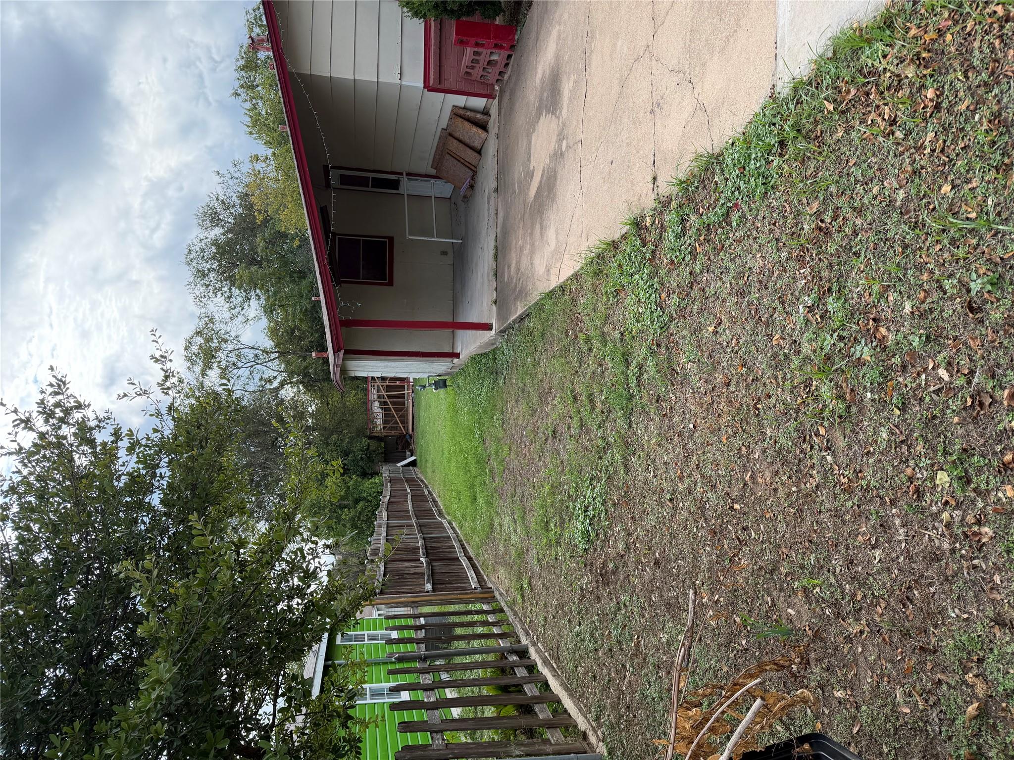 A long side yard runs alongside a covered carport