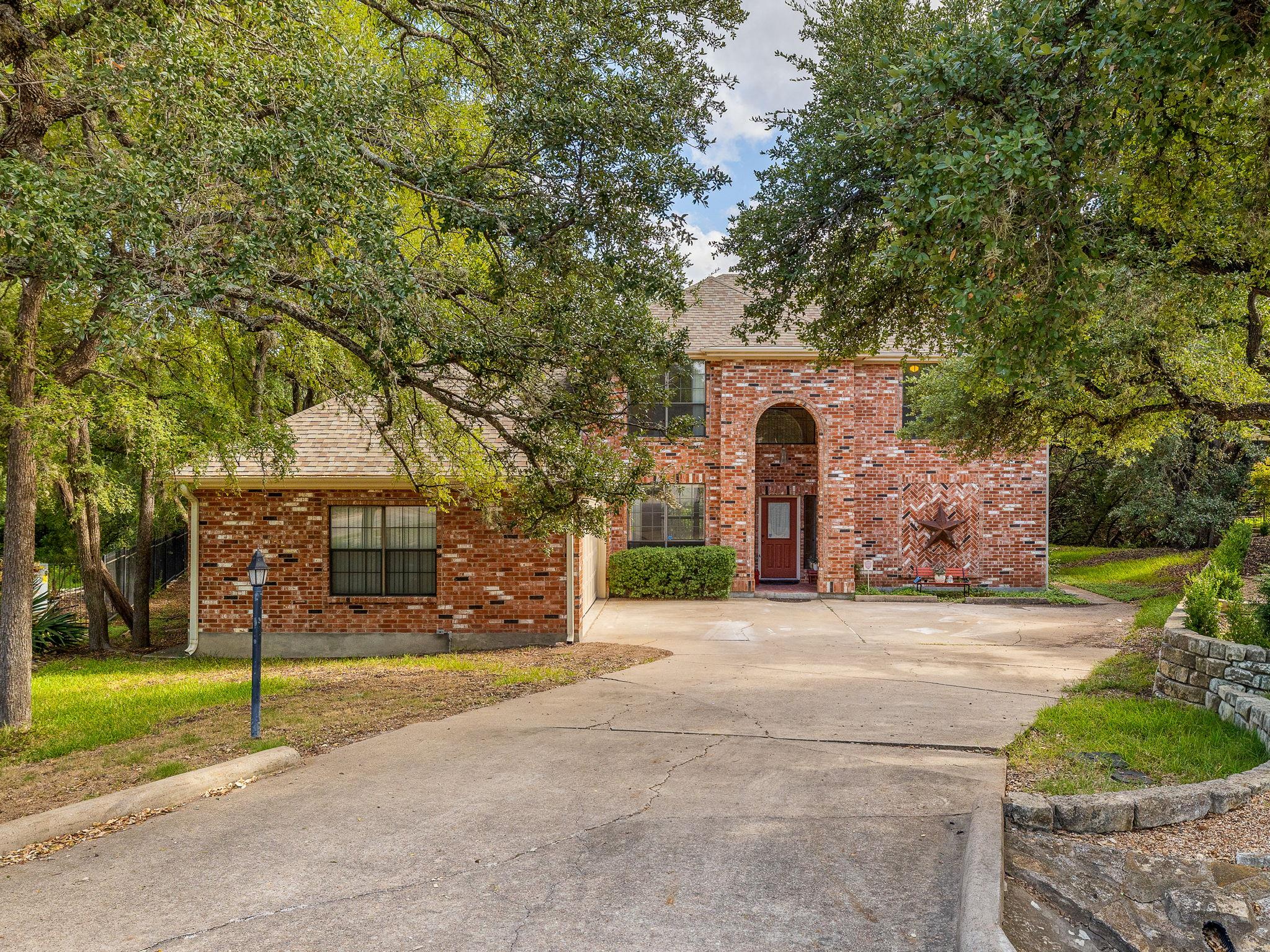 Mature trees frame a classic brick exterior with 