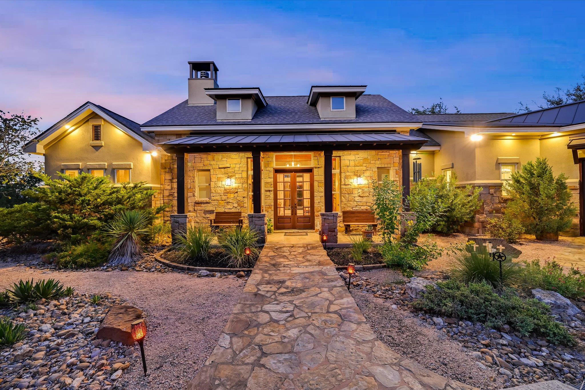 An inviting stone-accented facade stands framed b