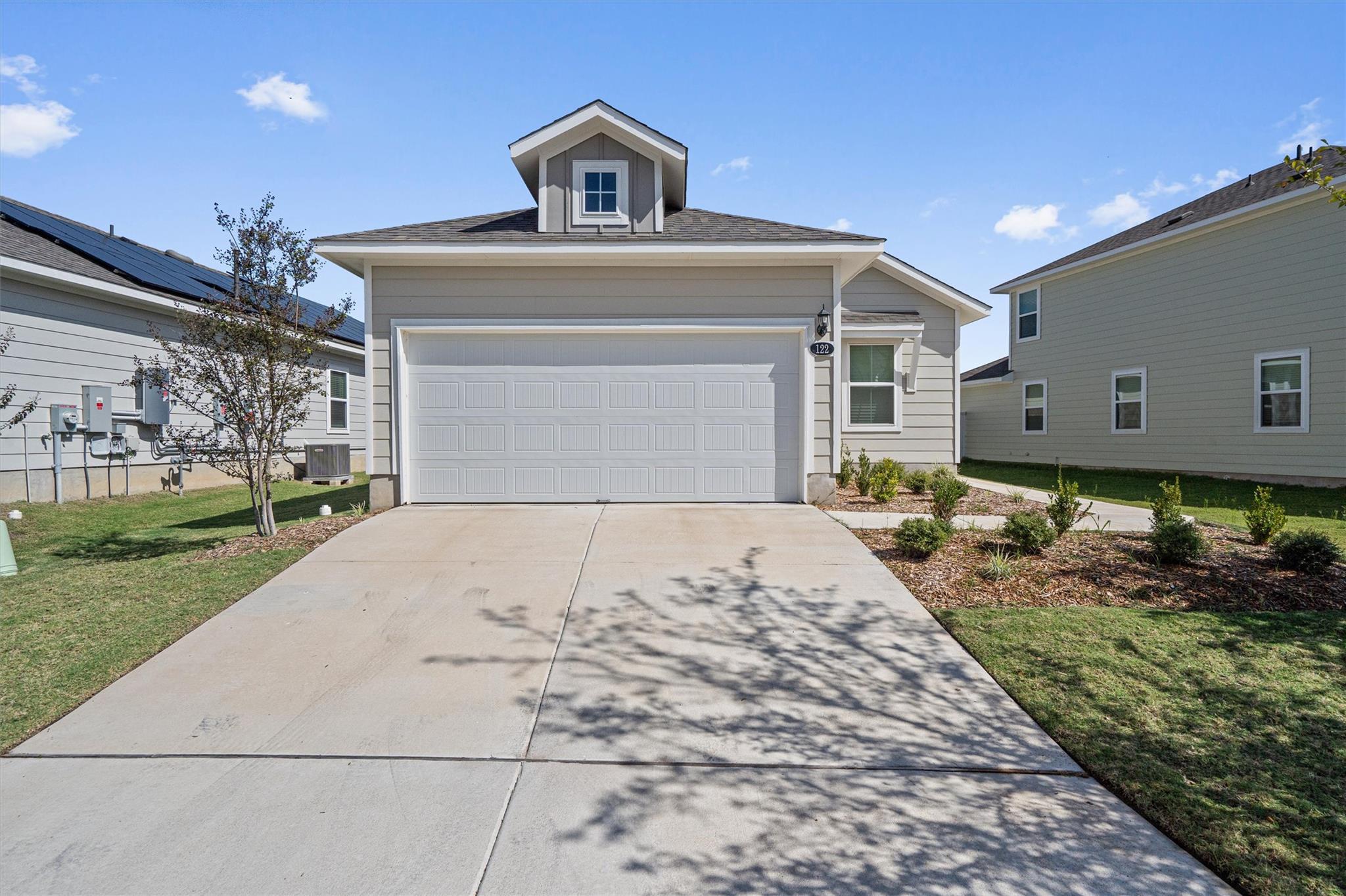 An inviting exterior features a concrete driveway