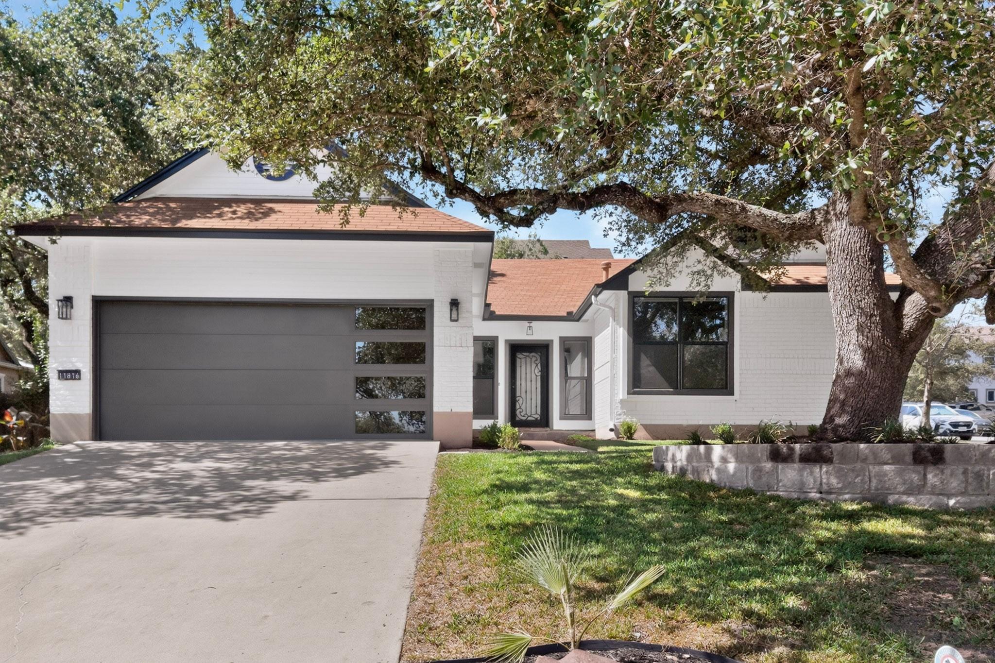 Mature oak trees shade a classic single-story fac