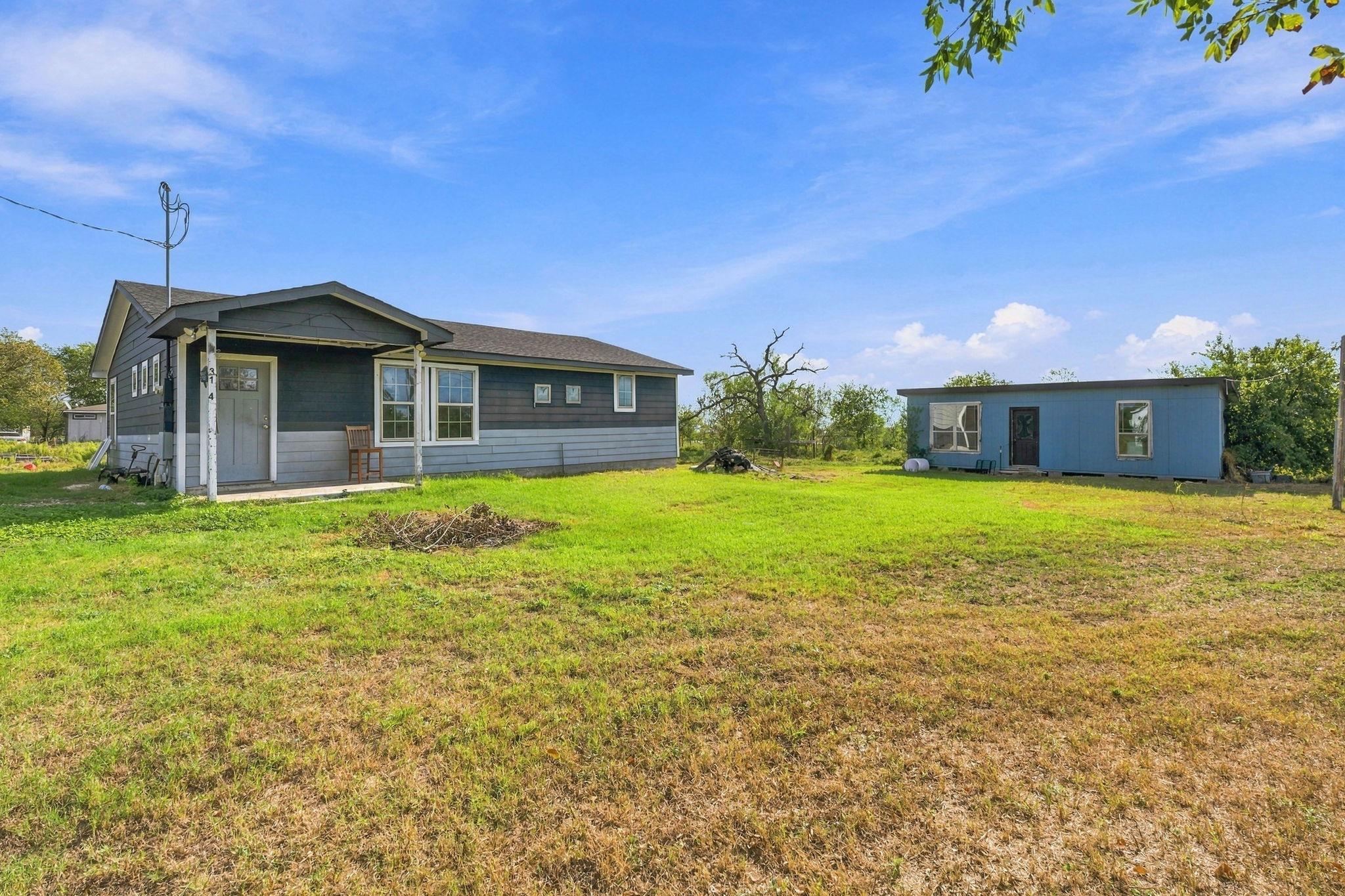 An expansive green yard surrounds this one-story 