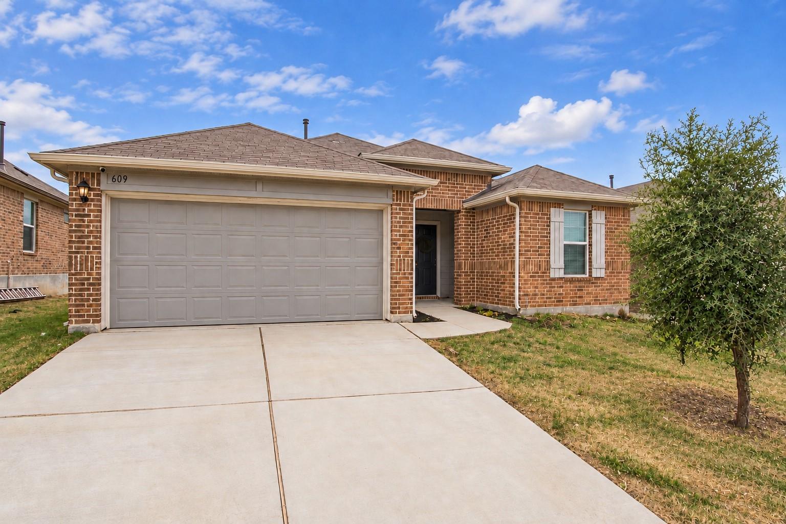 A classic brick exterior, concrete driveway, and 