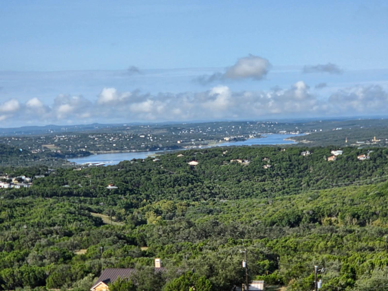Rolling green hills frame a distant winding blue 