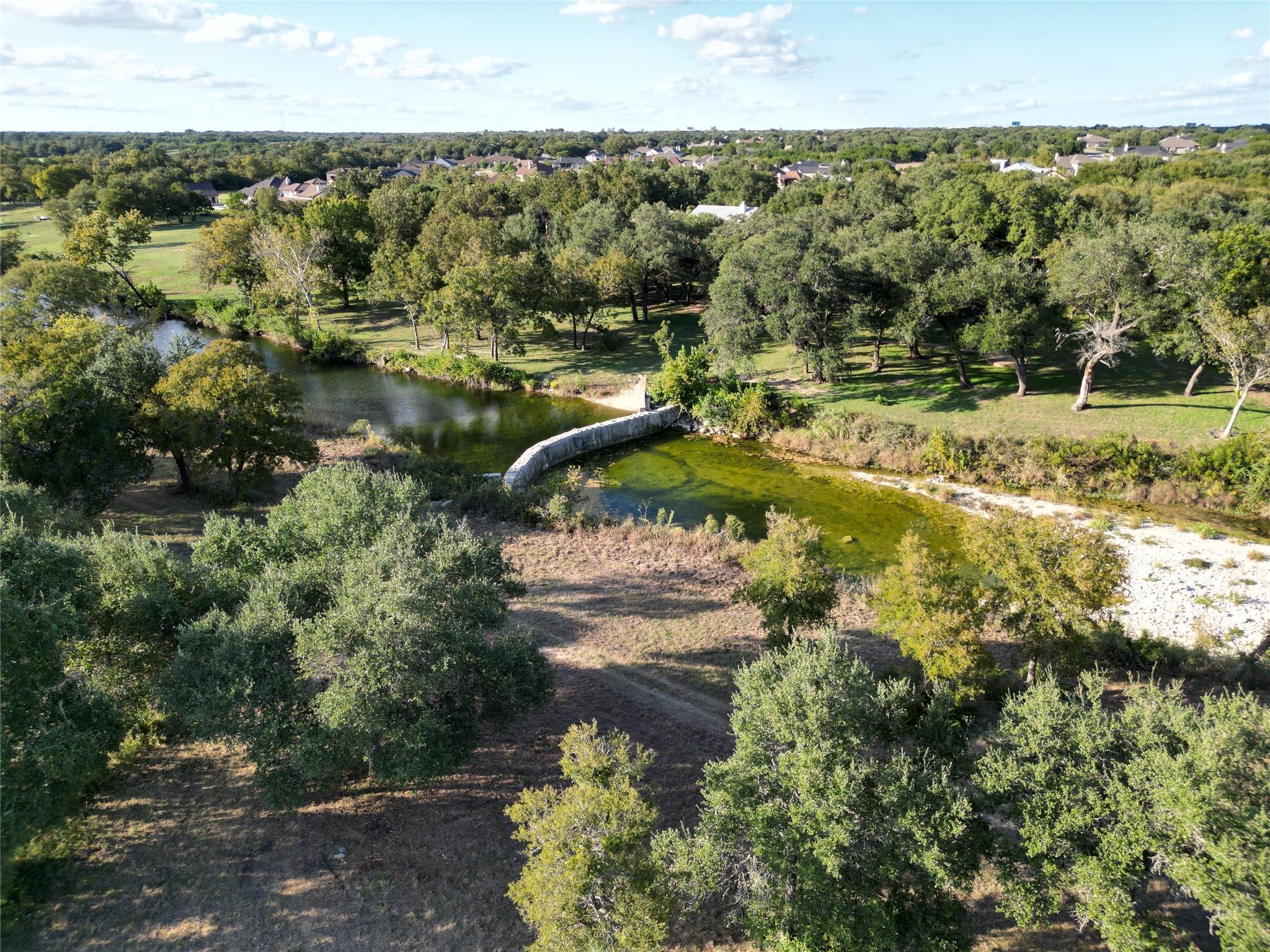 Mature trees and a winding waterway frame this sc